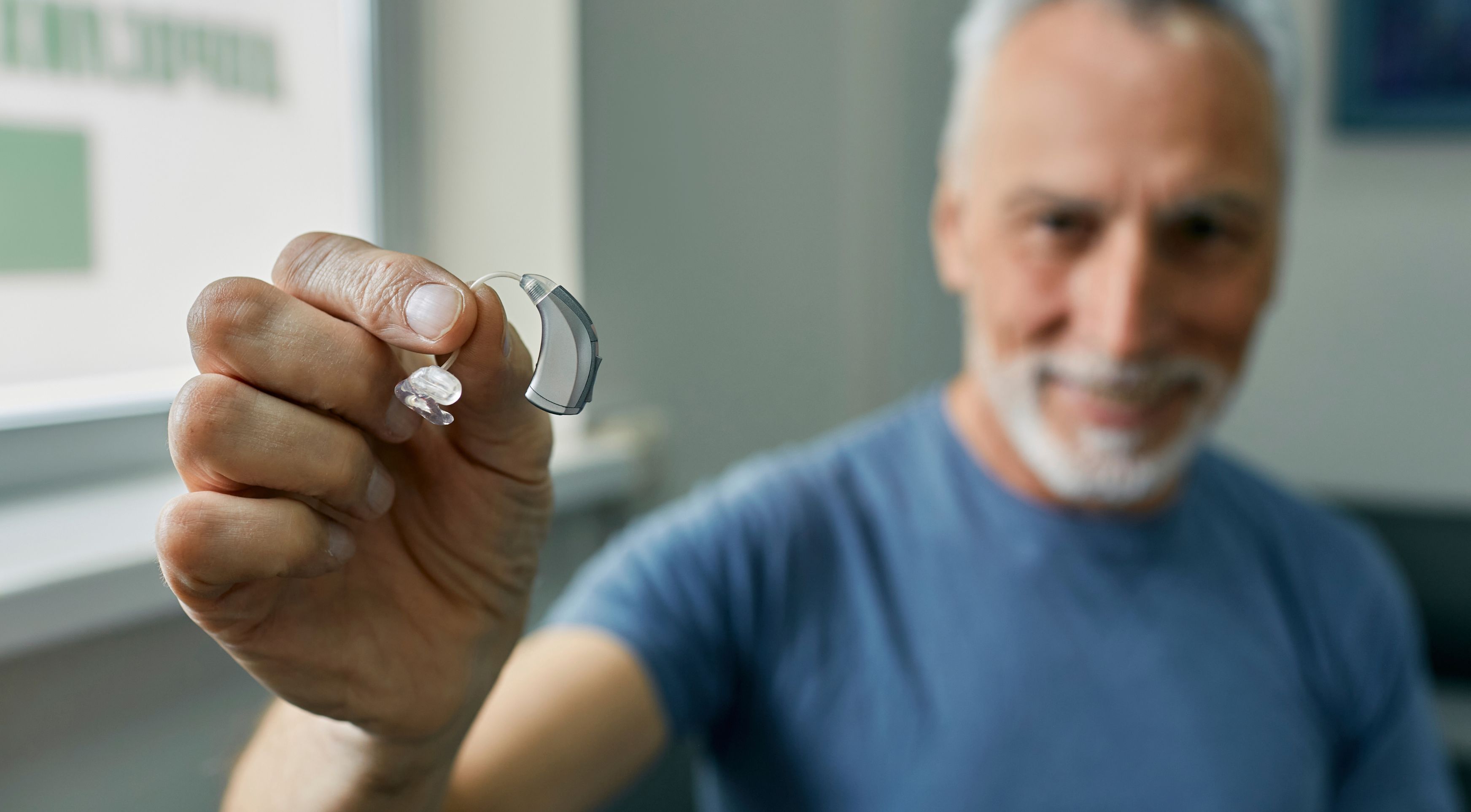 Sala de espera del centro auditivo con sofás beige, decoración cálida y ambiente acogedor