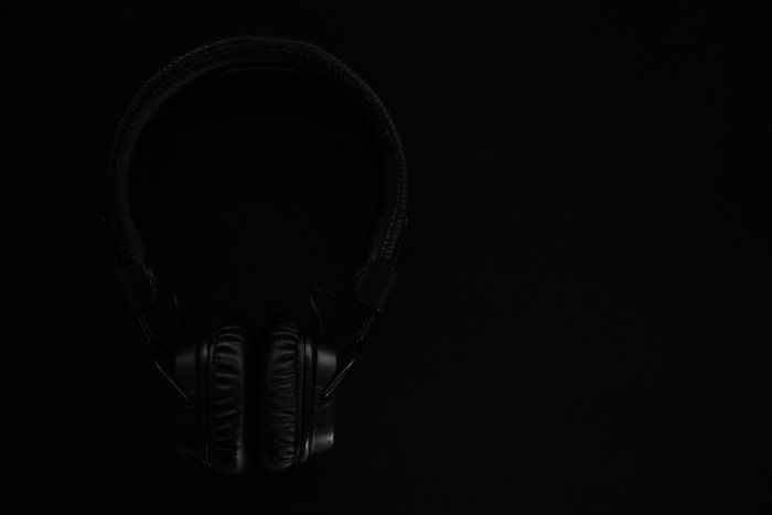 black and gray headphones on black surface (TEMPORAL - sustituir por foto real)