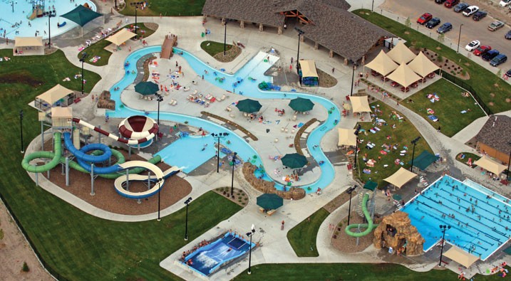 man in black shirt sitting on chair near white wooden house during daytime