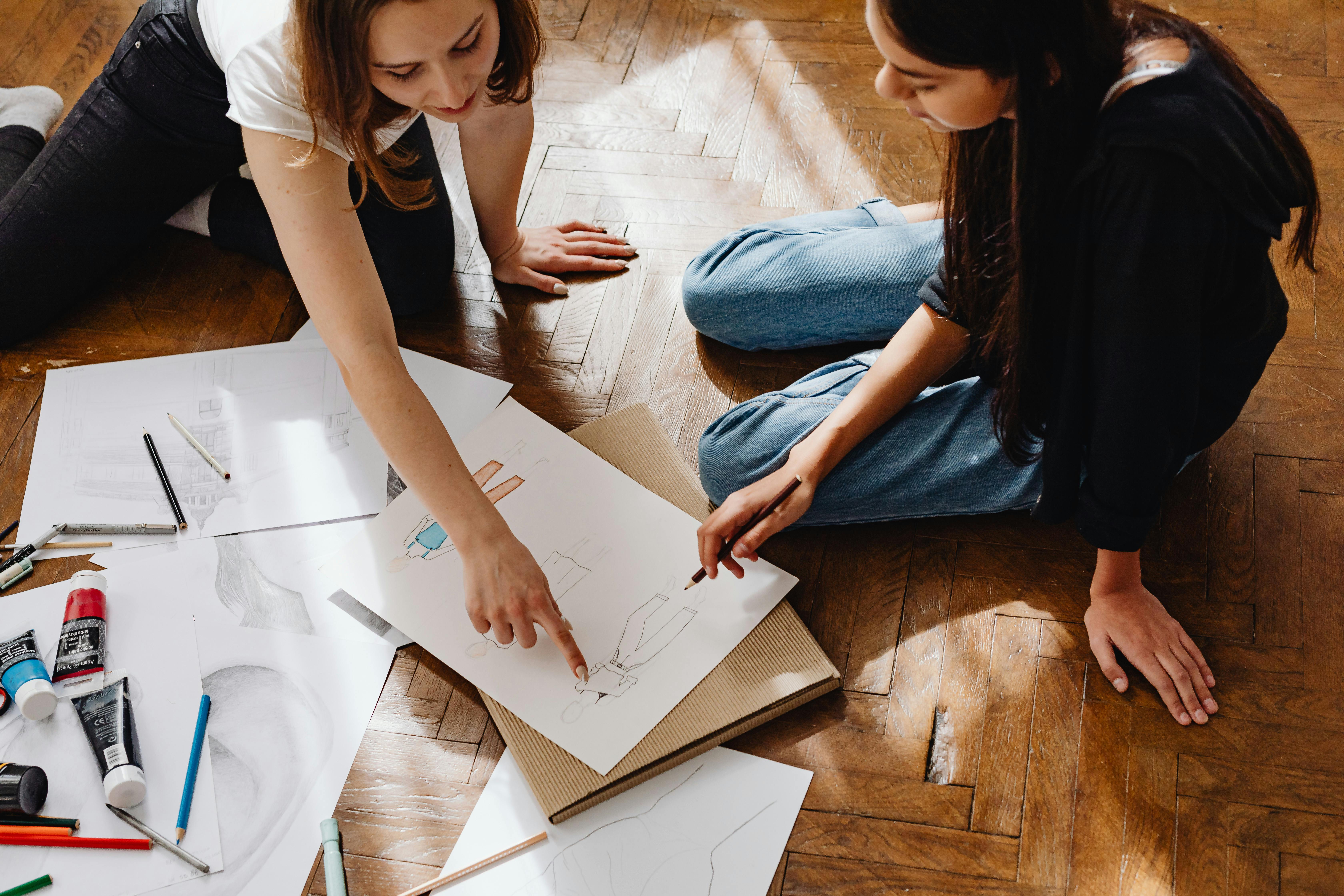 Two people drawing on the floor