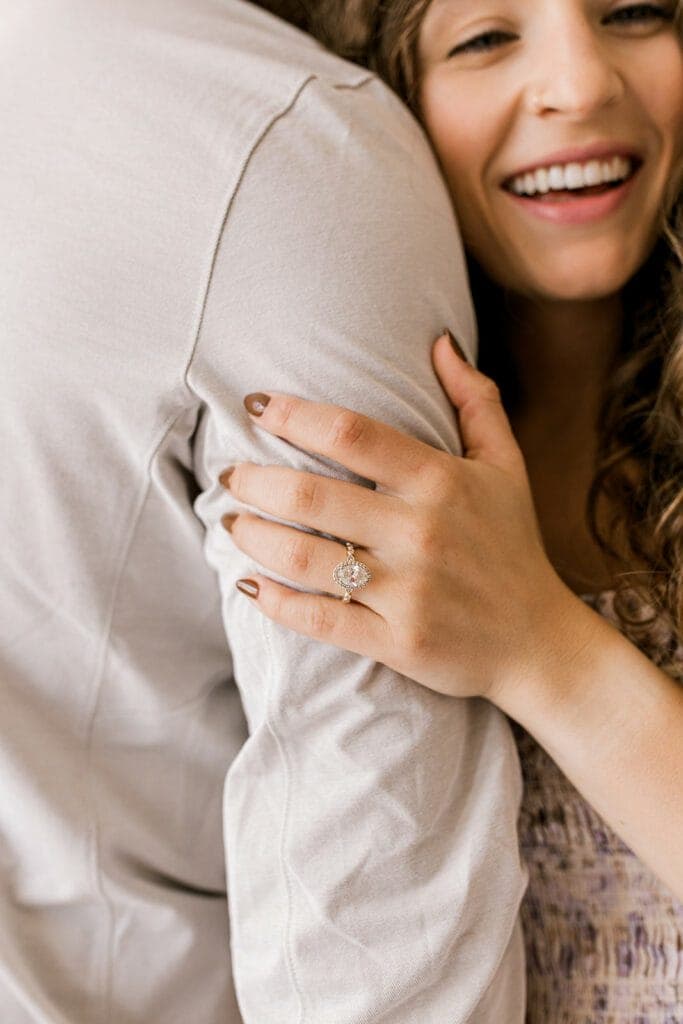 A close-up of the woman’s engagement ring as she lovingly holds her fiancé’s arm during their engagement session at Revelator Studio, Shreveport.