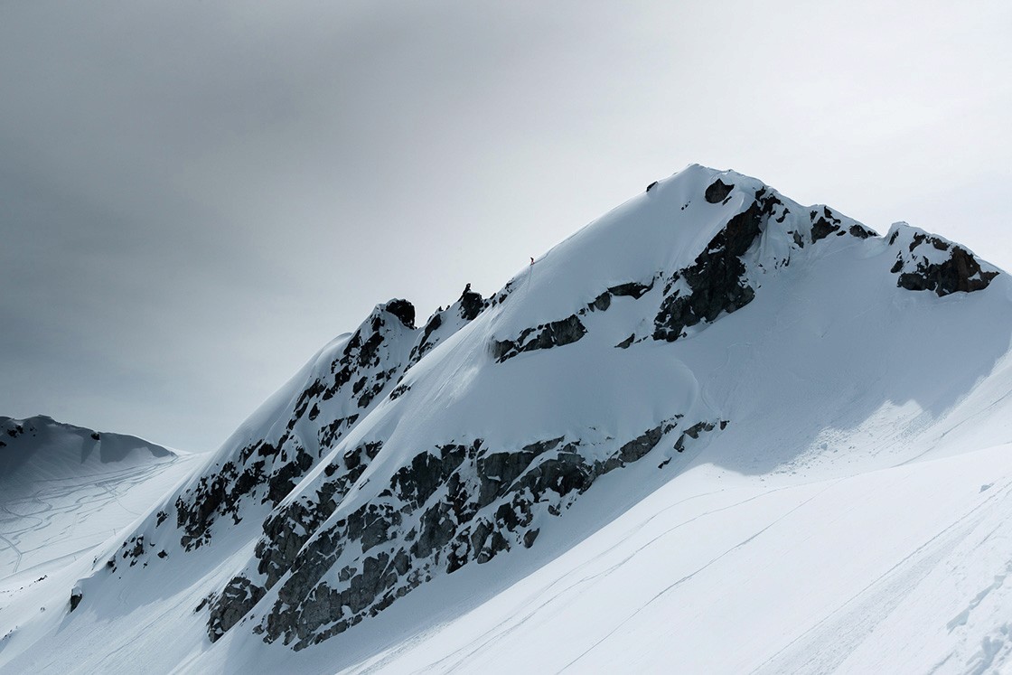 Wide view of Whistler mountain cliffs with a snow border, Canada.