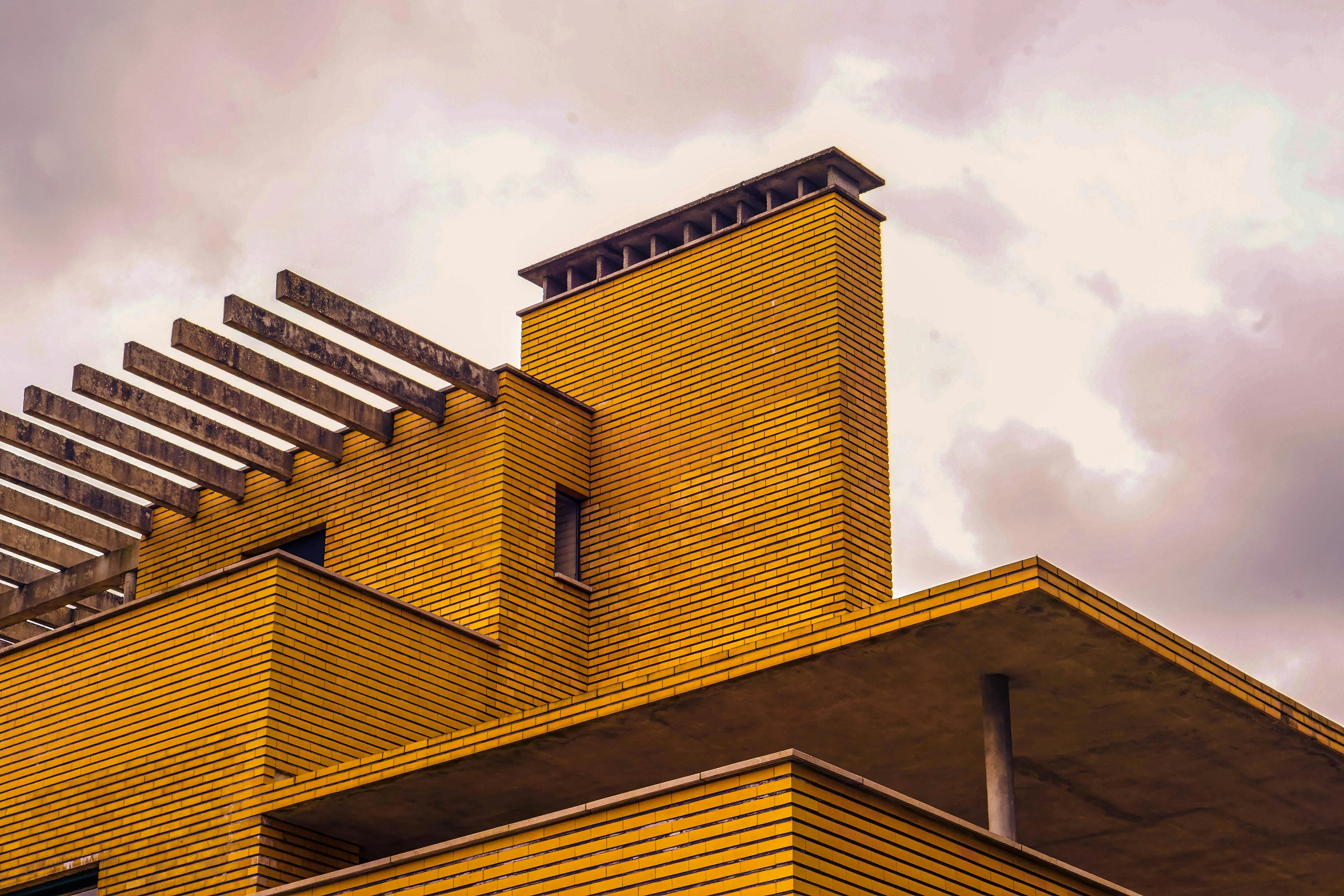 Close-up of a modern building's unique architectural features under a cloudy sky.