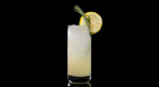A closeup of a Sweet, Spring Spiked Peach Lemonade drink against a dark background.