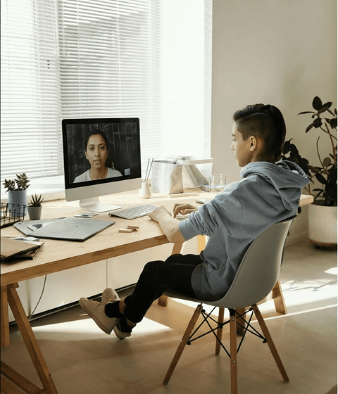A video call with a teacher is displayed on the screen