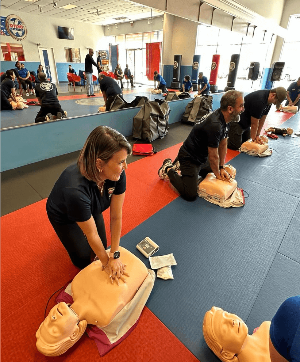 Okito team members practicing CPR moves for a certification class.