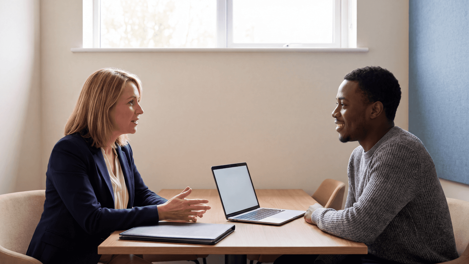 A business owner and an employee talking across a desk about health plan choices