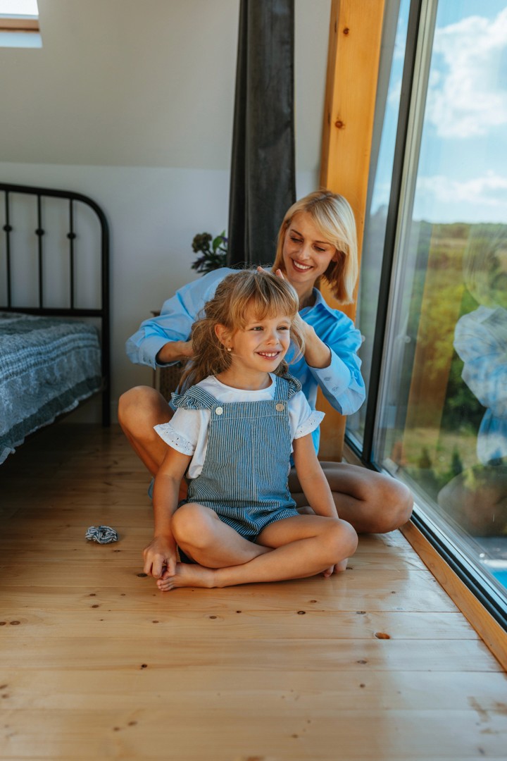 Mutter mit Kind vor einem großen Fenster