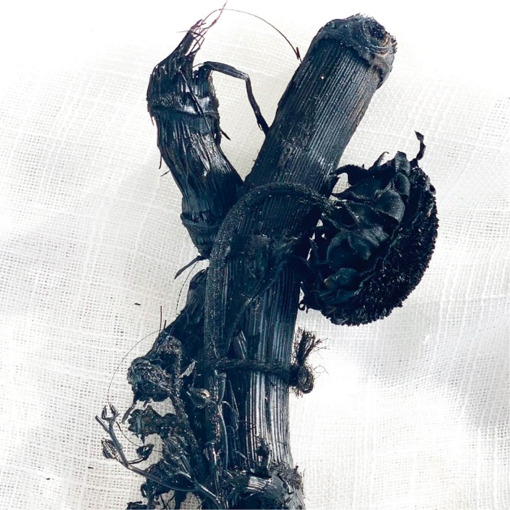 A wabi-sabi inspired monochrome black dried flower arrangement with driftwood