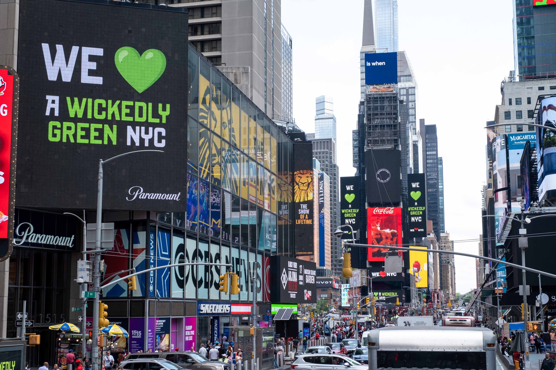 View of Times Square with a billboard that reads "We love a wickedly green NYC"