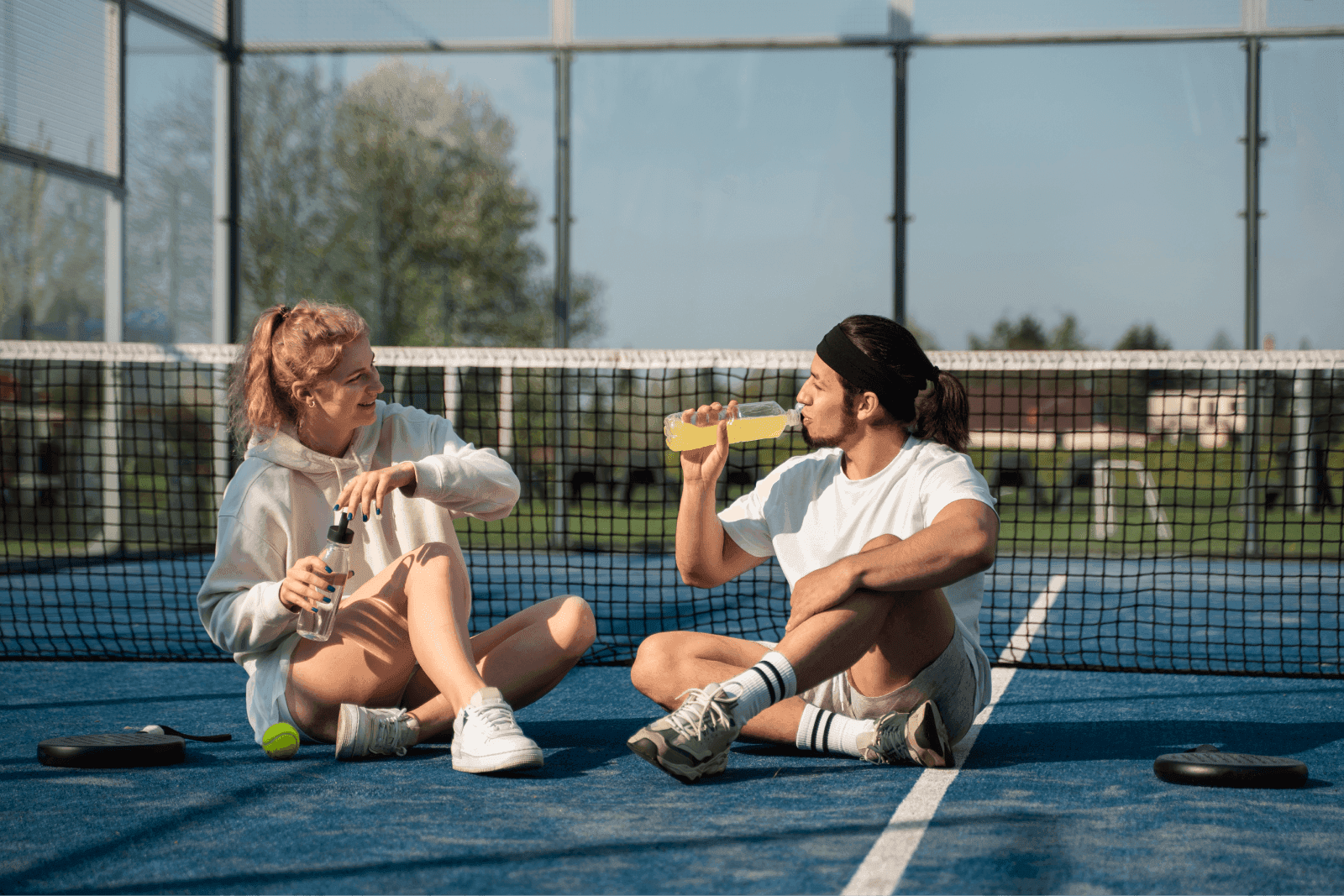 2 young padel players sitting and relaxing