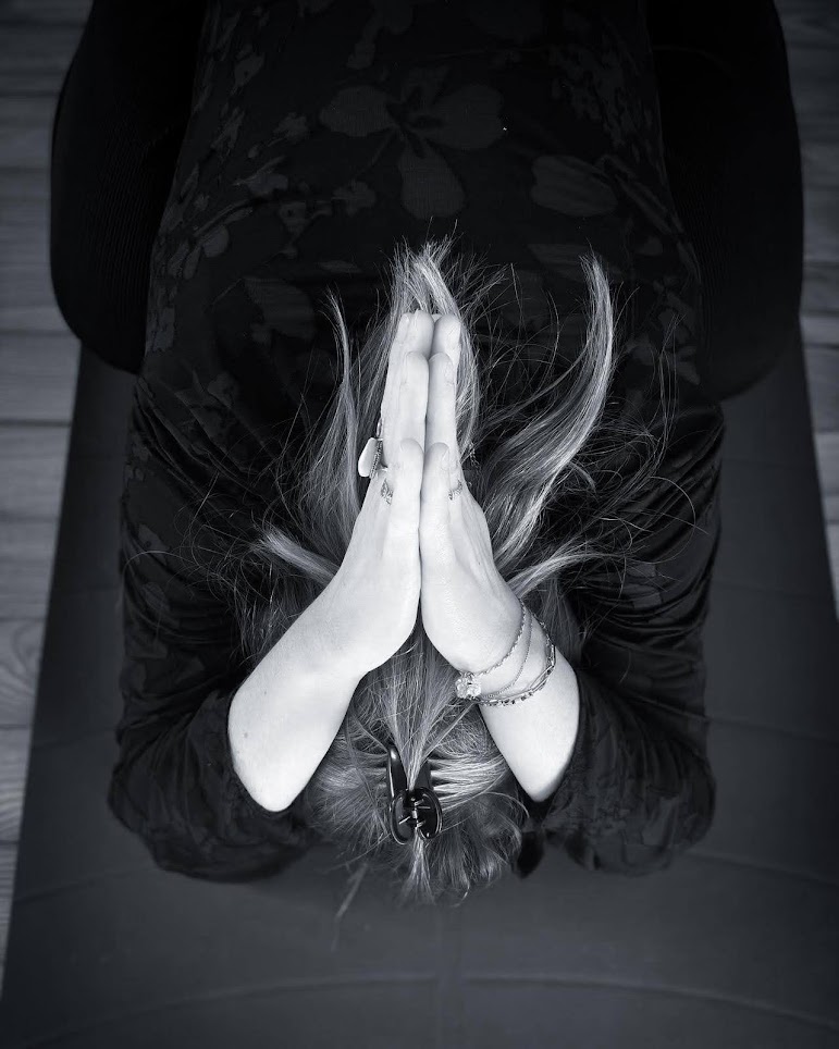 image de la page d'accueil ou hero section du site dédié au yoga sur desktop et tablet, vue de face, mains collées paume contre paume en arrière de la tête, position de yoga accroupie.