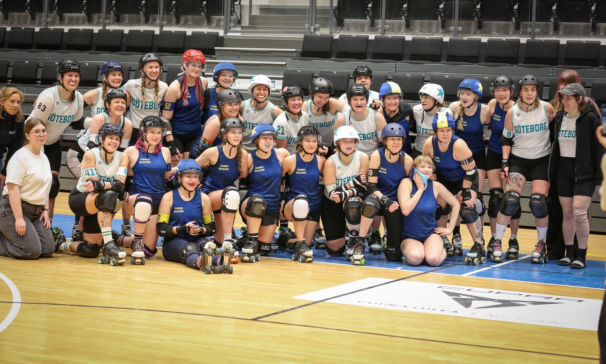 Two roller derby teams posing for a group photo.