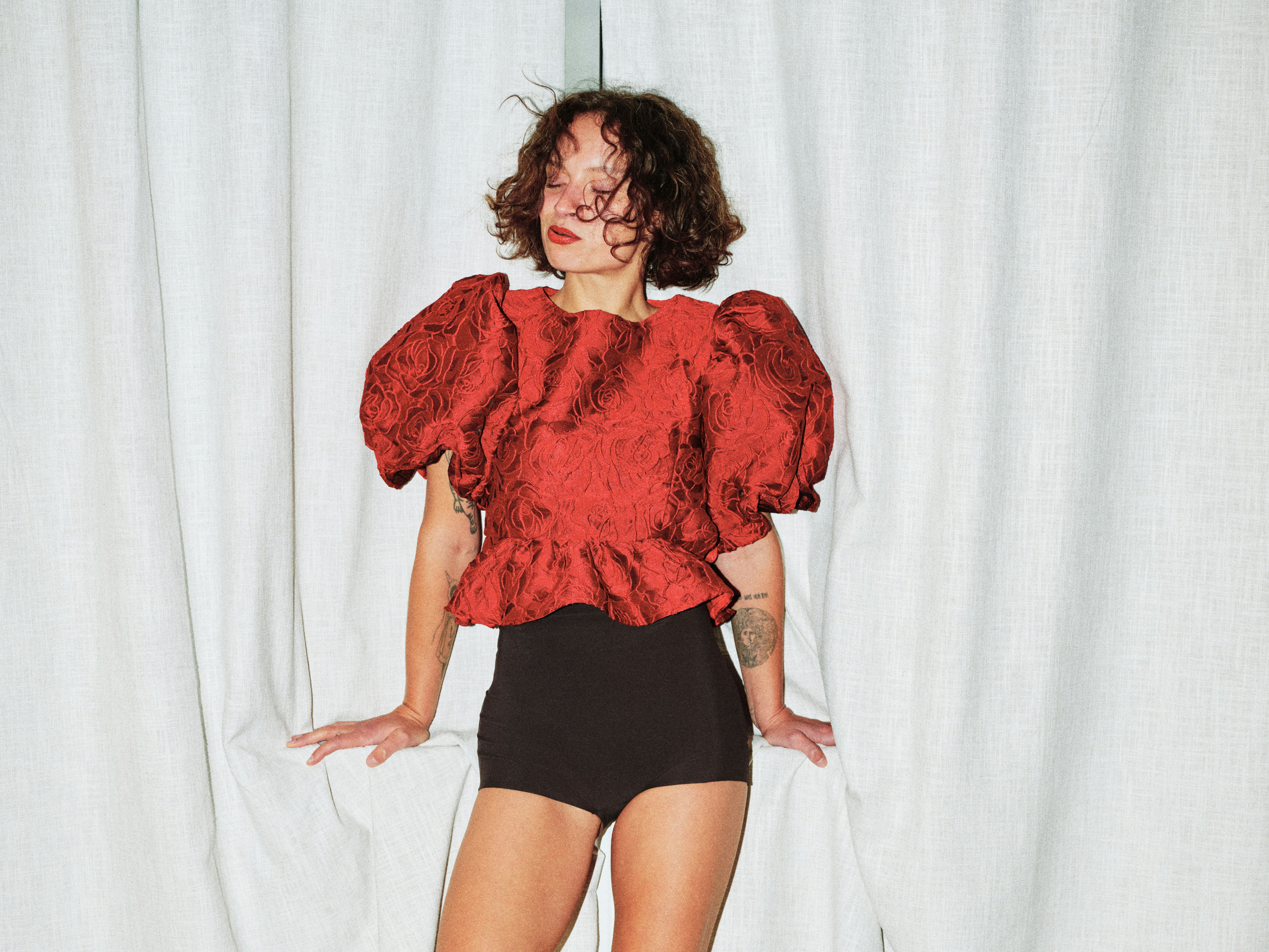 woman in a red top and black shorts