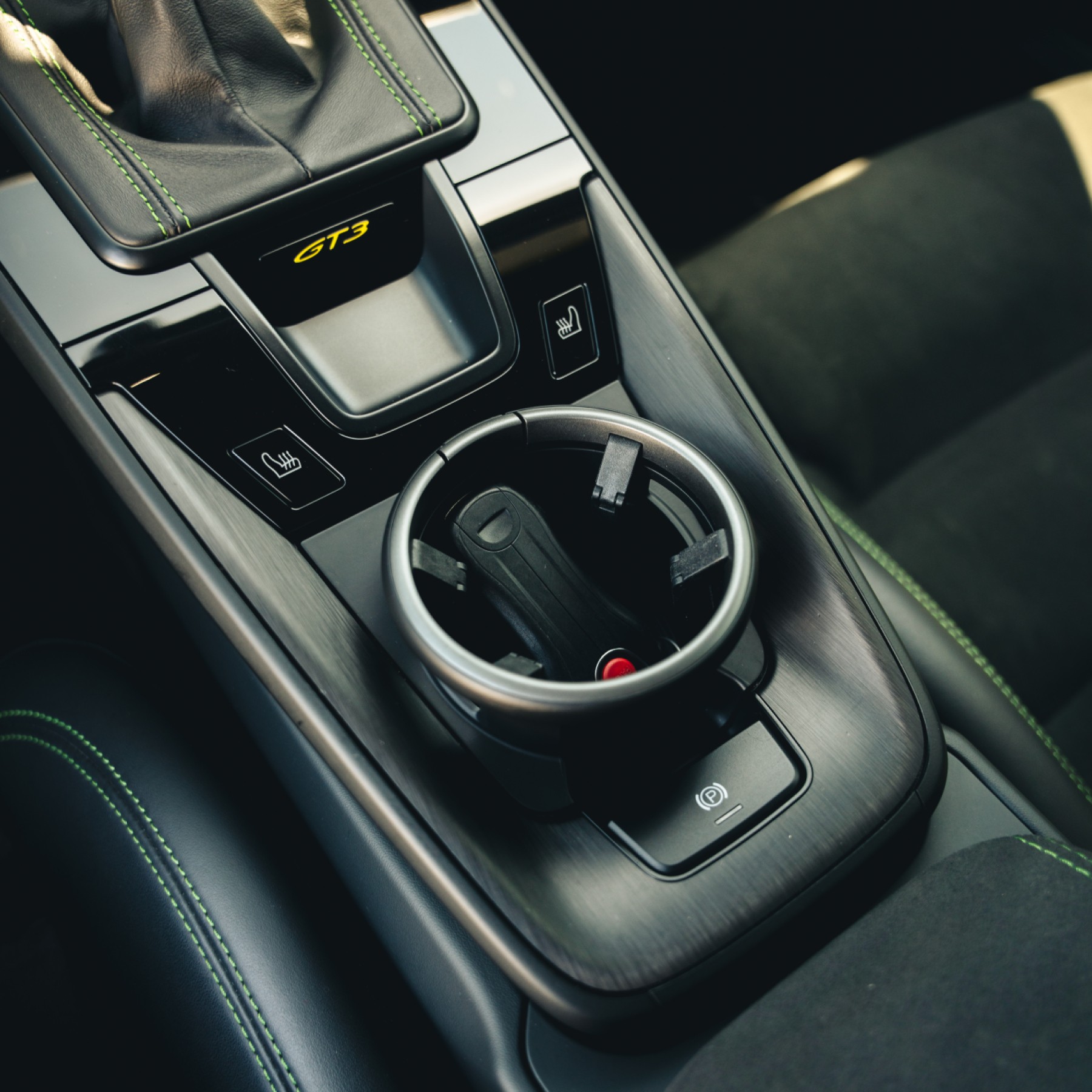 Interior view of Porsche 911 GT3 dashboard and center console, showcasing modern controls and minimalist design.