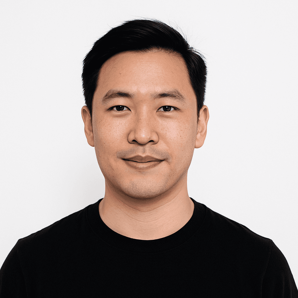 Man with short black hair wearing a black crew-neck shirt.