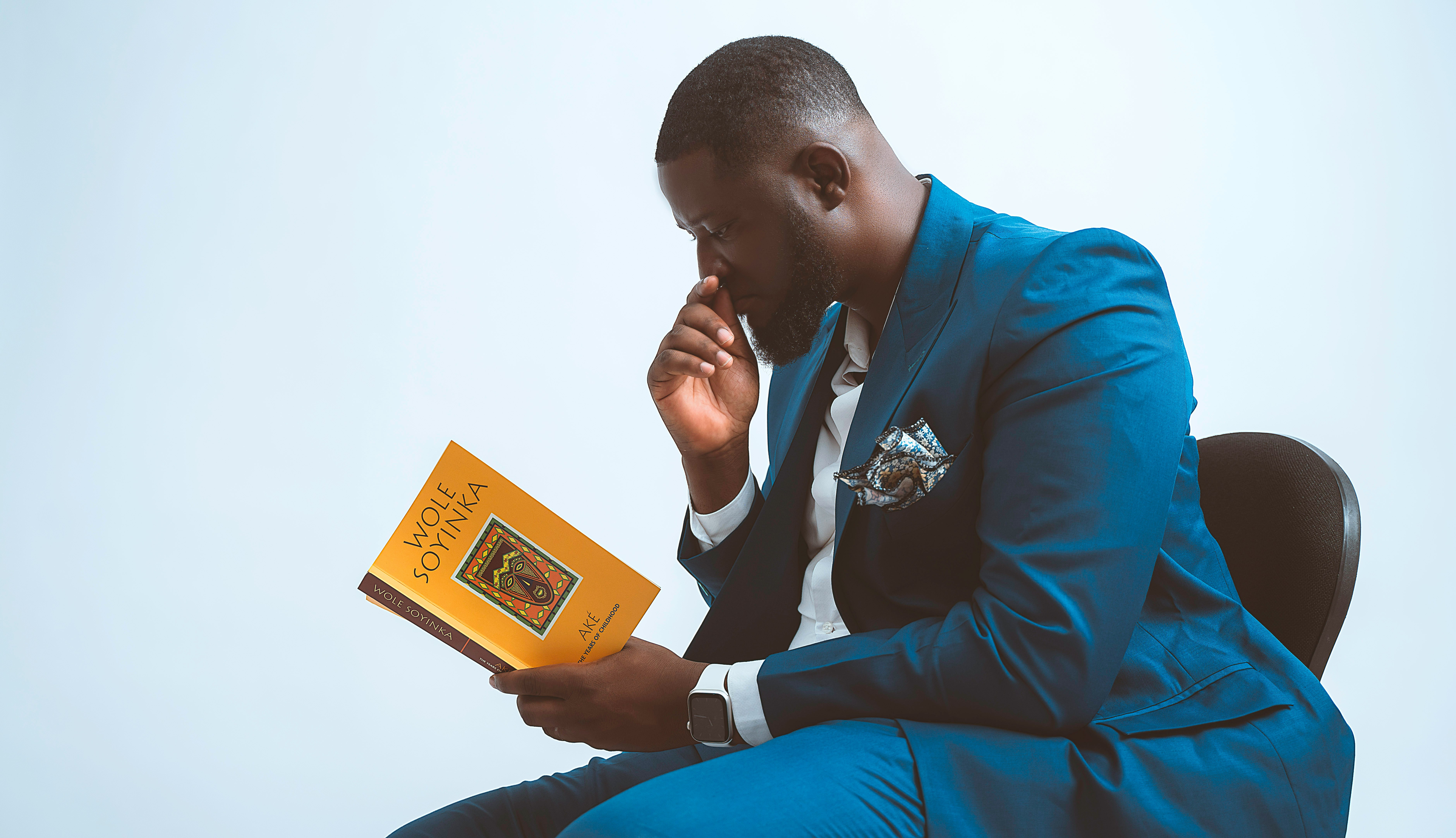a man in a blue suit is reading a book
