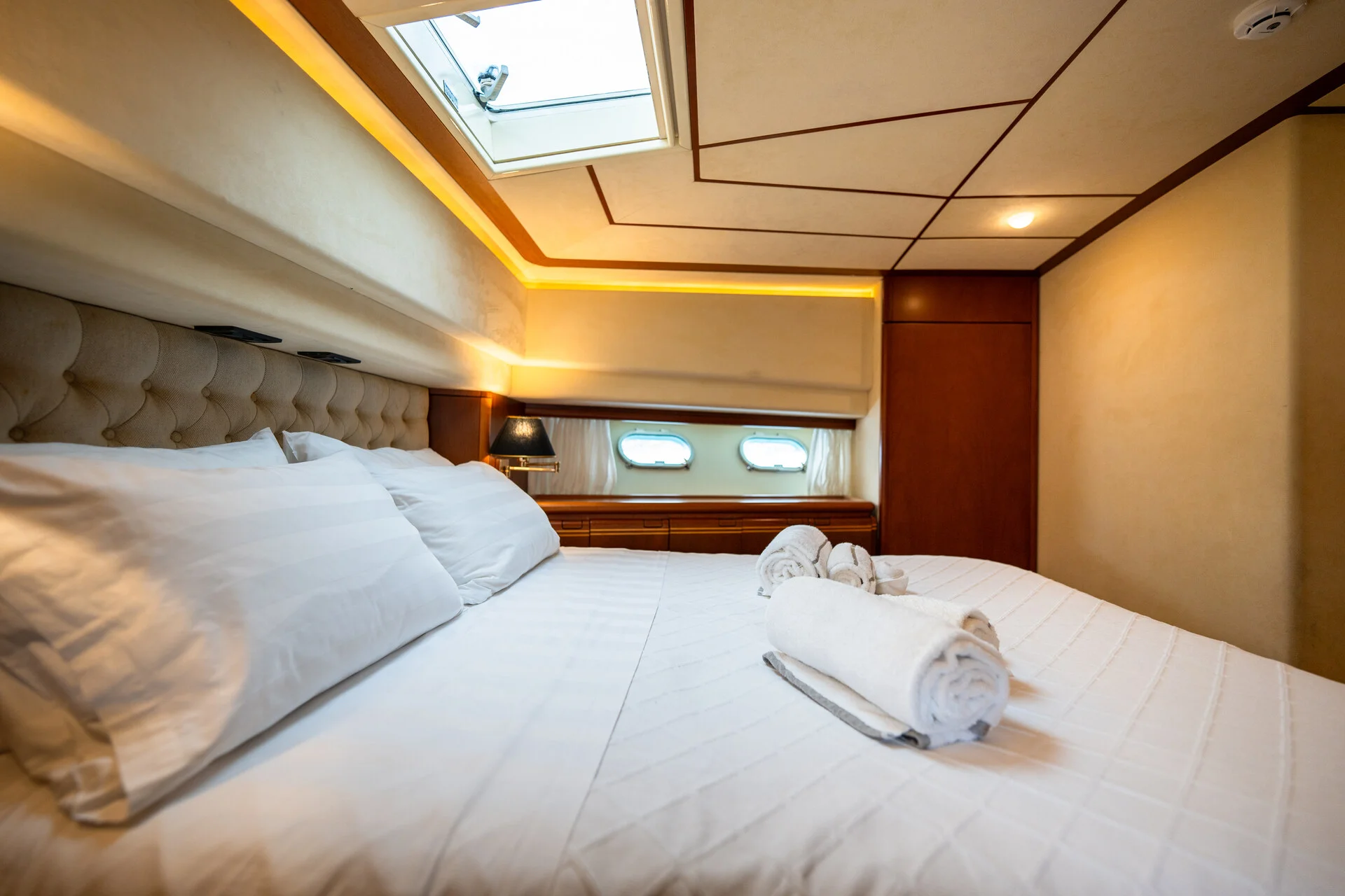White Rock 36 speedboat with captain at helm cruising calm blue waters near Paros coastline with hills in background.