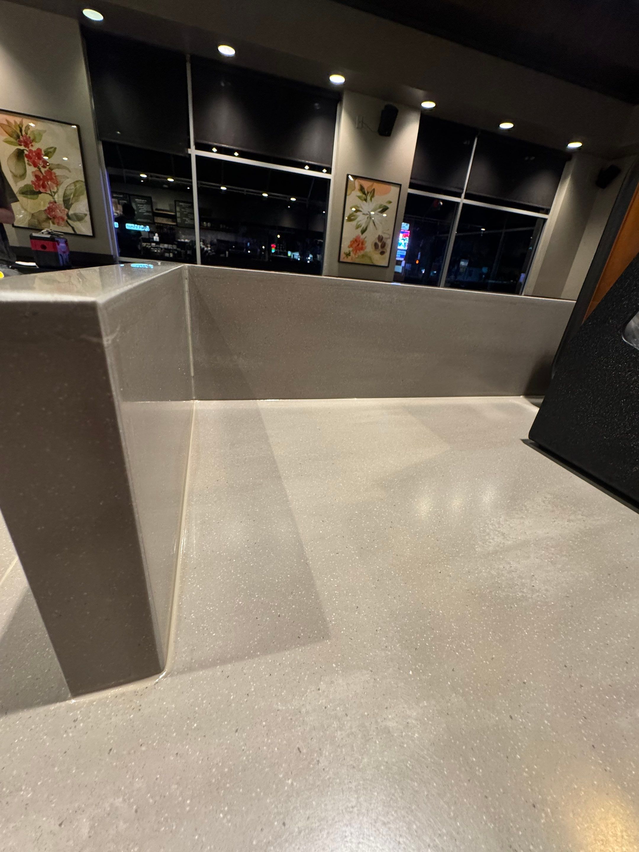 Close-up of Starbucks countertop corner and splash guard showing precise seam alignment and smooth, durable finish under store lighting.