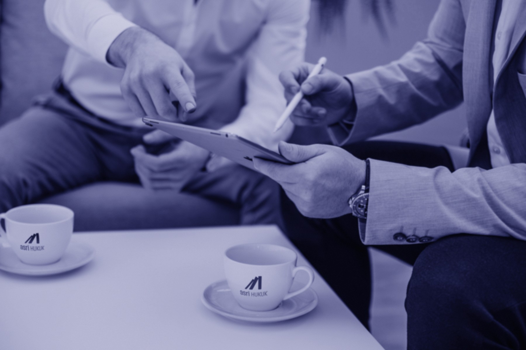 A restaurant interior featuring marble countertops, brown leather chairs, wood-paneled walls, and round pendant lights hanging above a bar set with wine glasses.