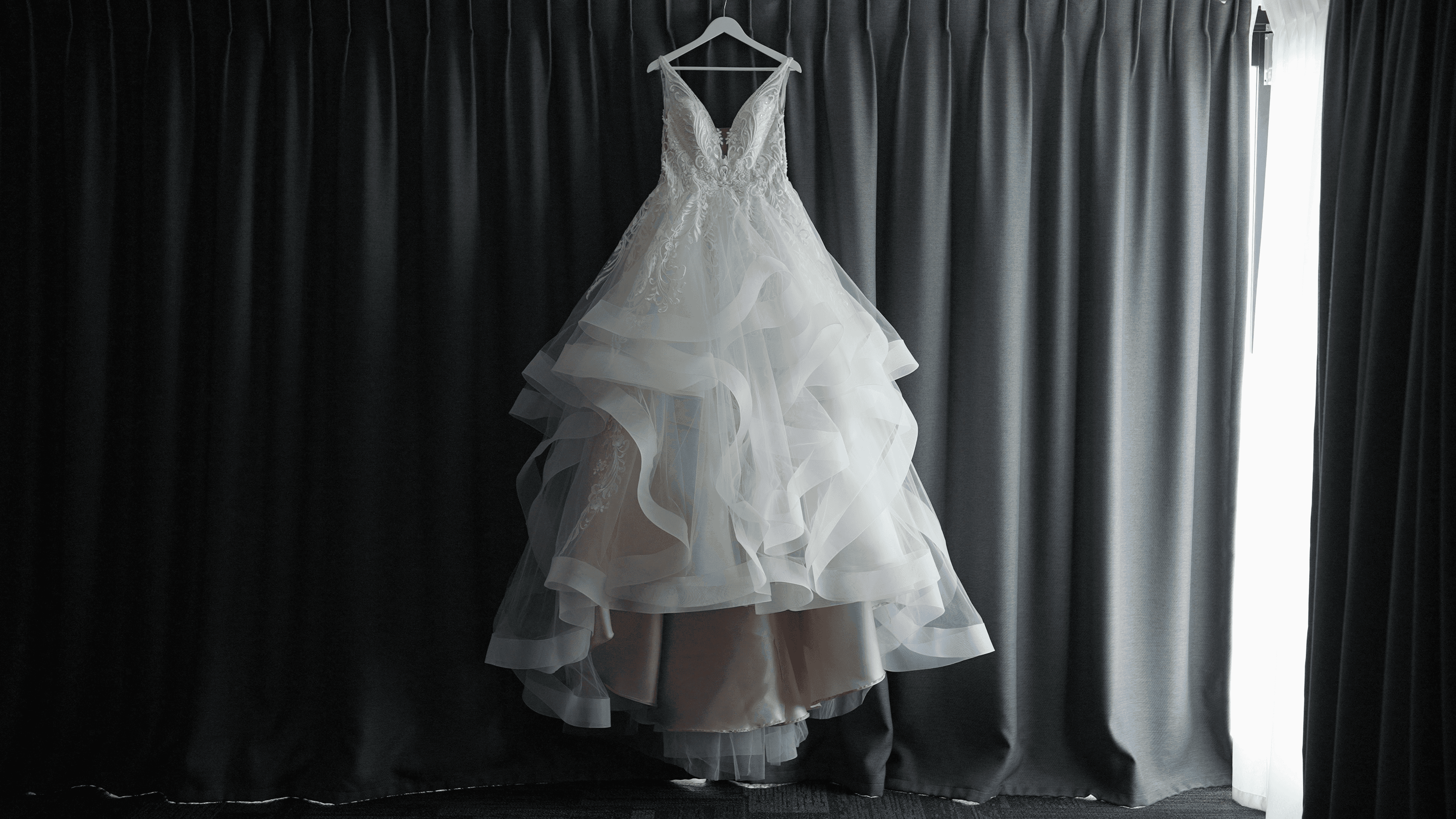 Wedding dress hanging to ger beautiful wedding videos taken of it for a couple getting married at Bundaleer Rainforest Gardens, Brisbane