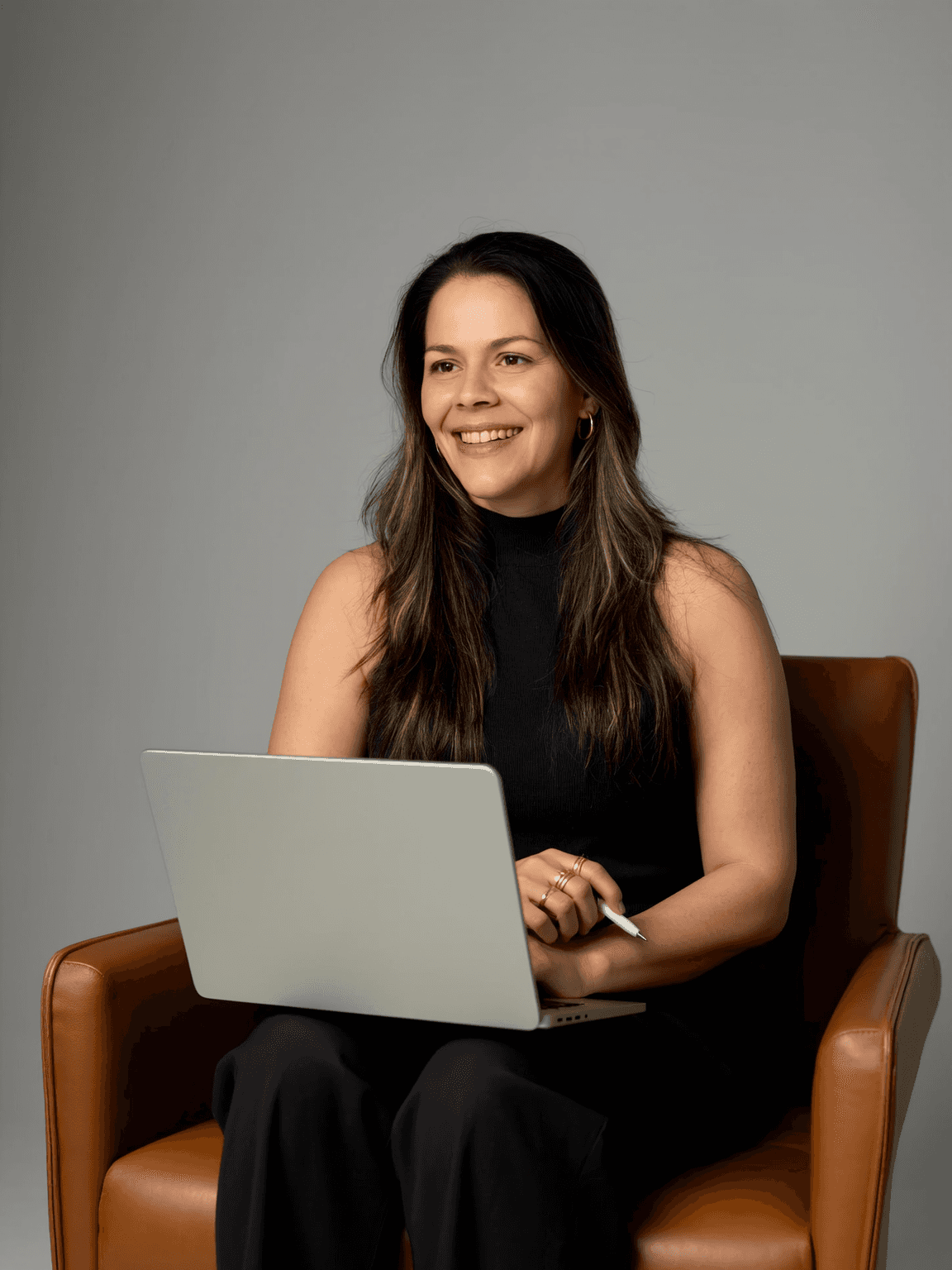Woman working on a laptop computer at a table in a bright room.