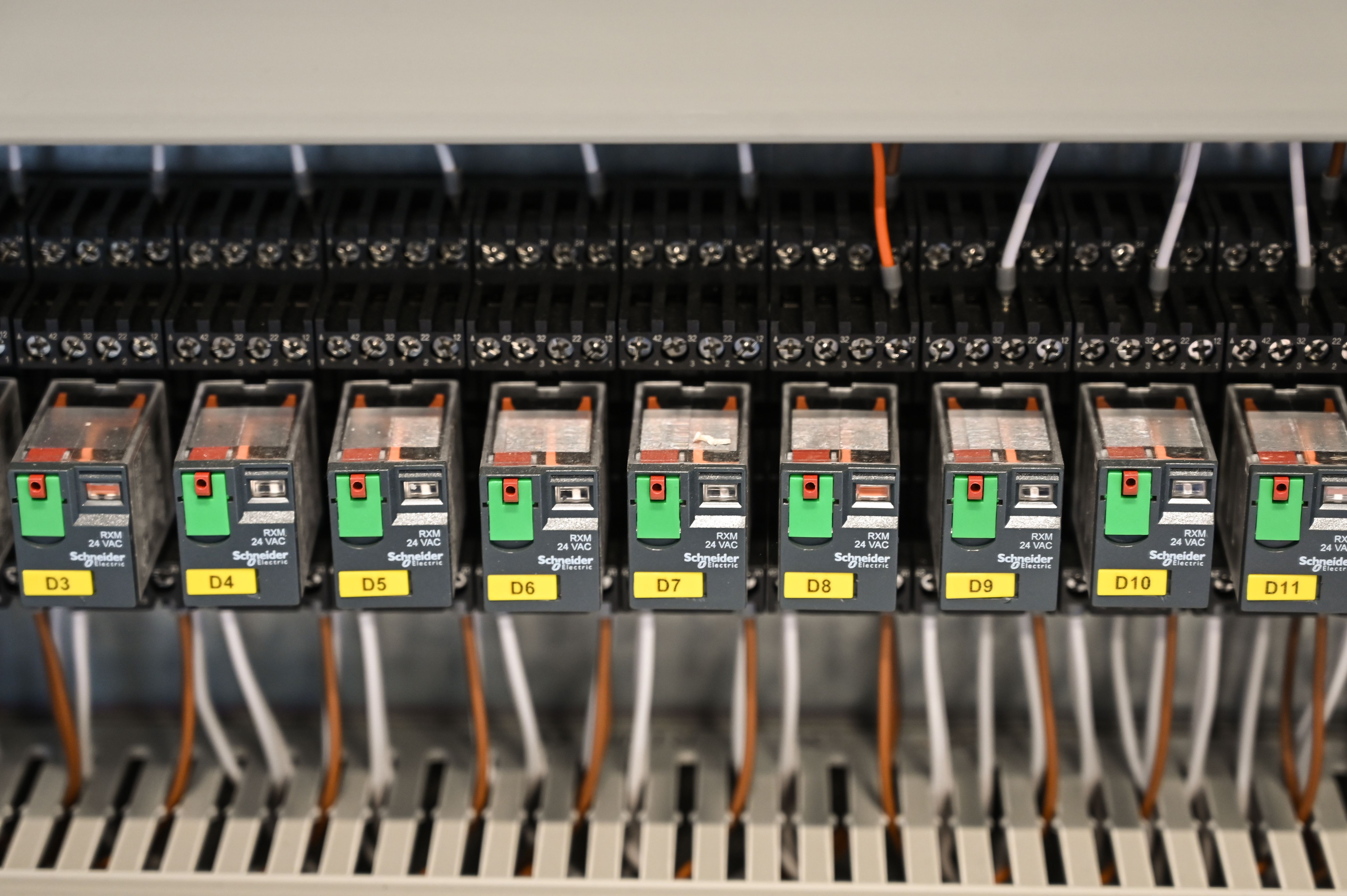 Electrical relays and wiring inside an industrial distribution panel.