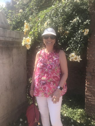 A photo of a woman wearing a pink dress while standing in a garden.