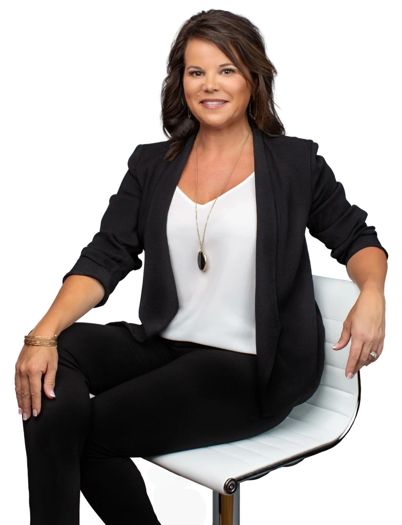 Photo of Tricia Garzon smiling, sitting on a chair looking at the camera