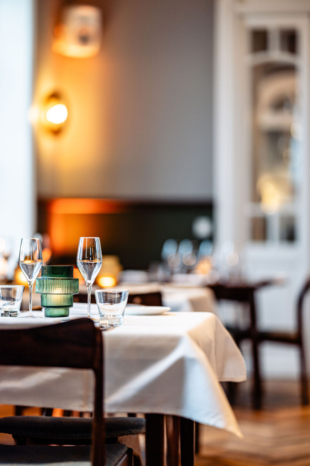 Posh restaurant interior with blue walls and large chandelier in the center