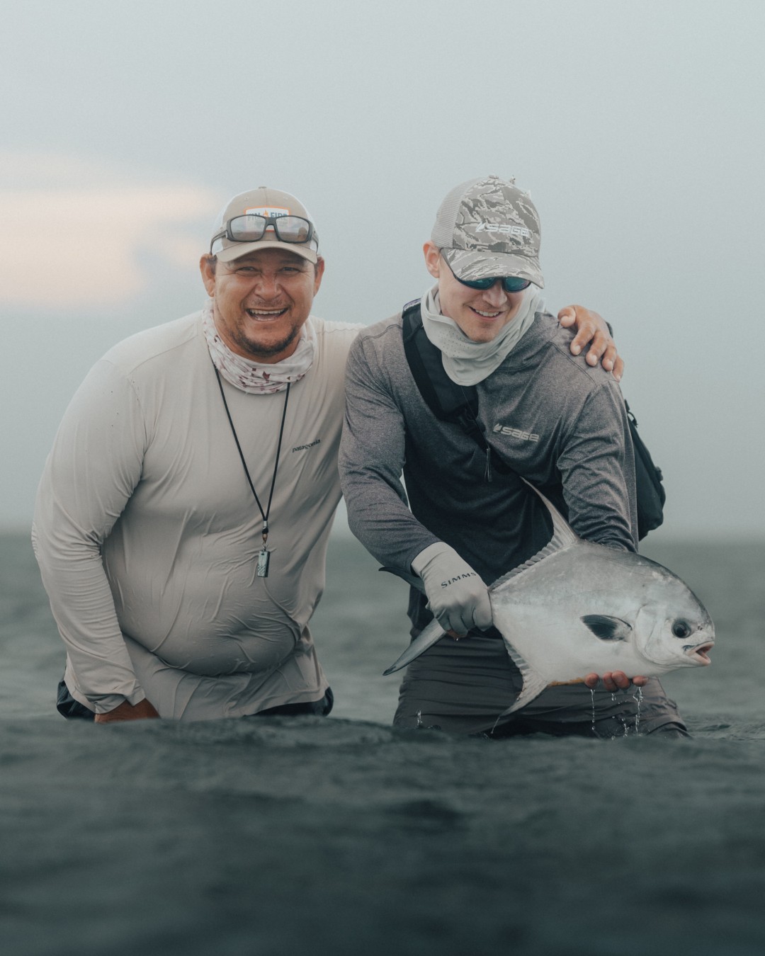 Fly fishing guide Marlon Leslie and a saltwater angler holding a permit on a flat in Belize