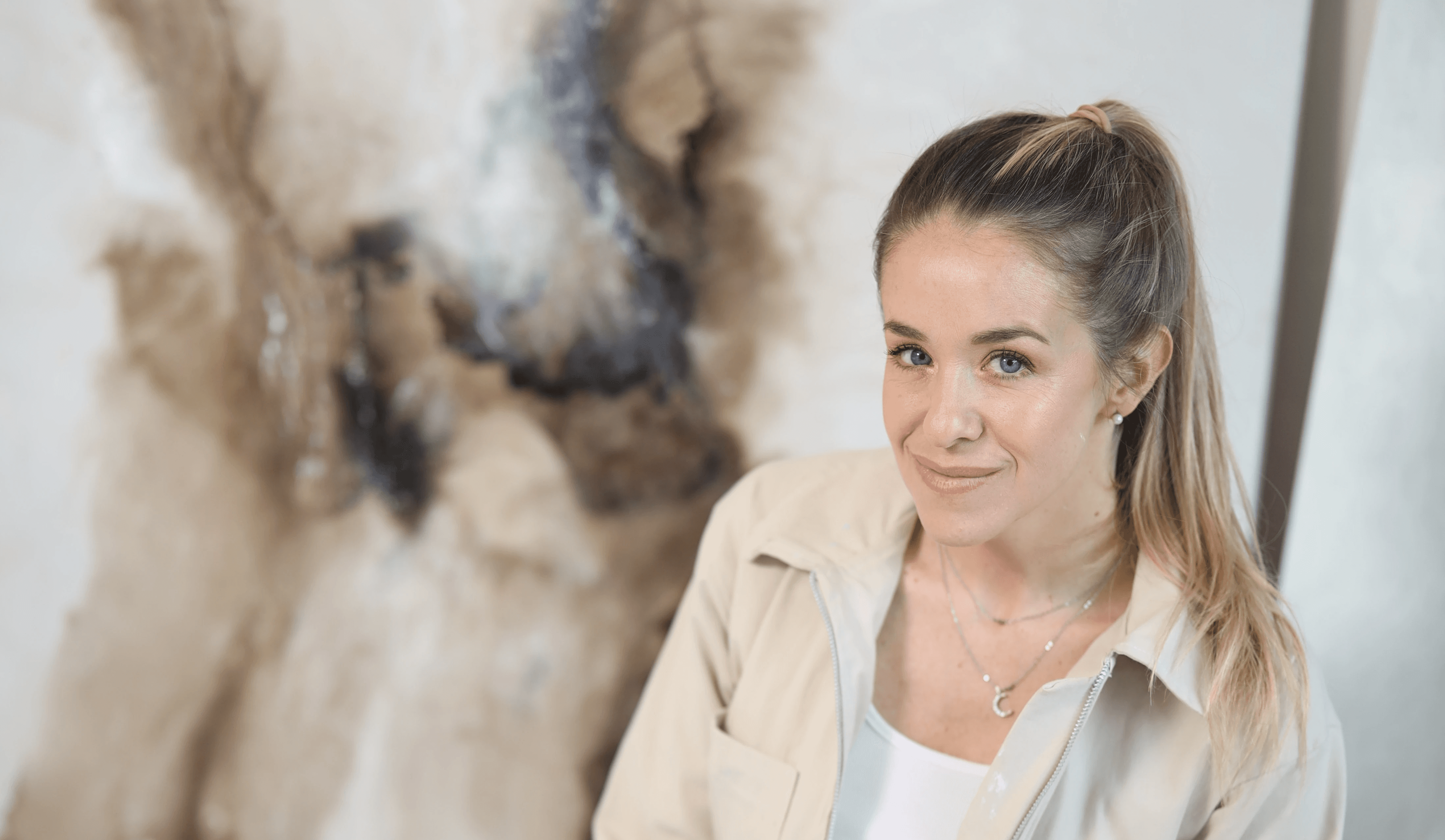 Lorena Matarraz posing next to her painting