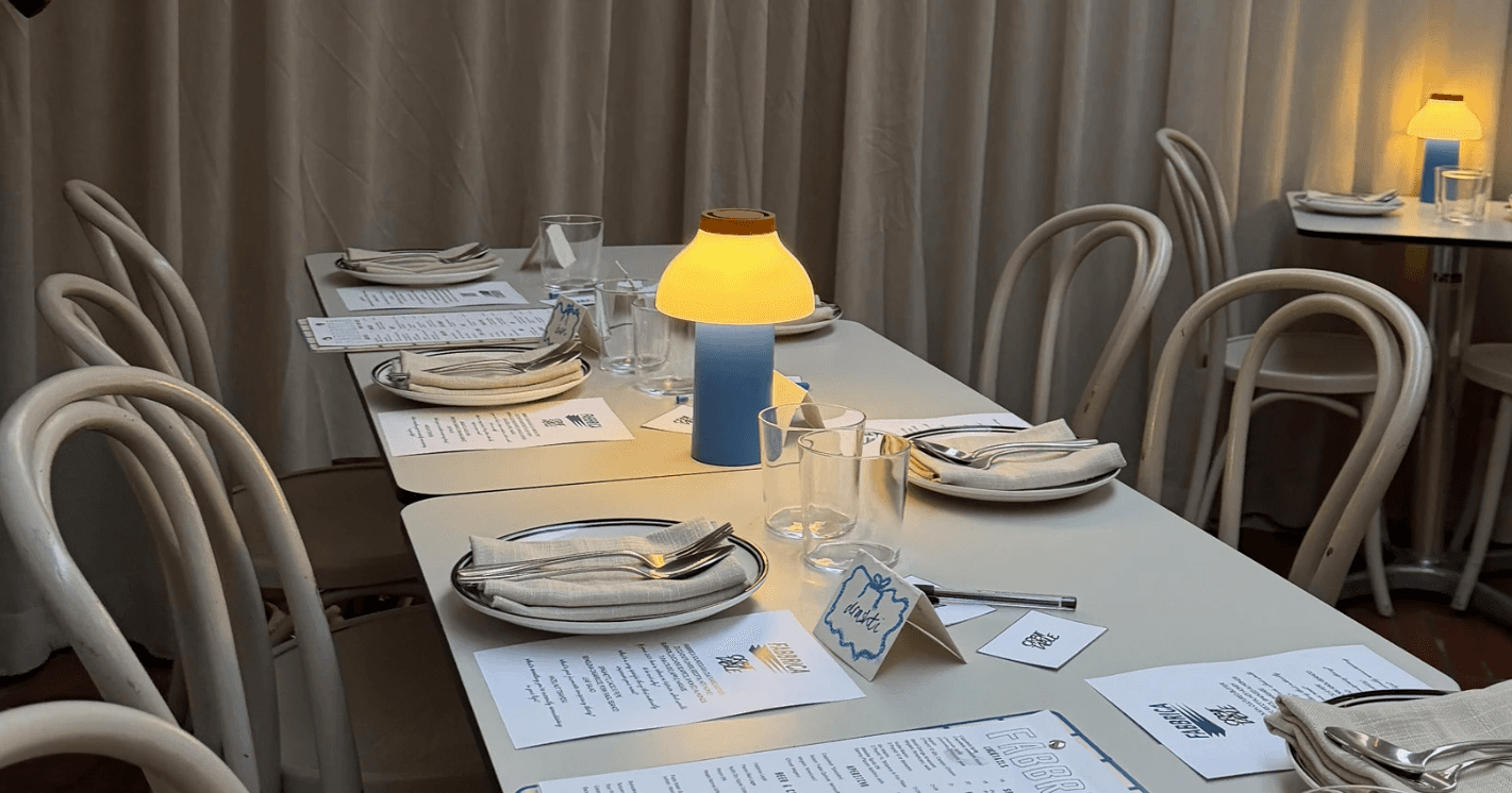 group of friends laughing at the table with food and drinks