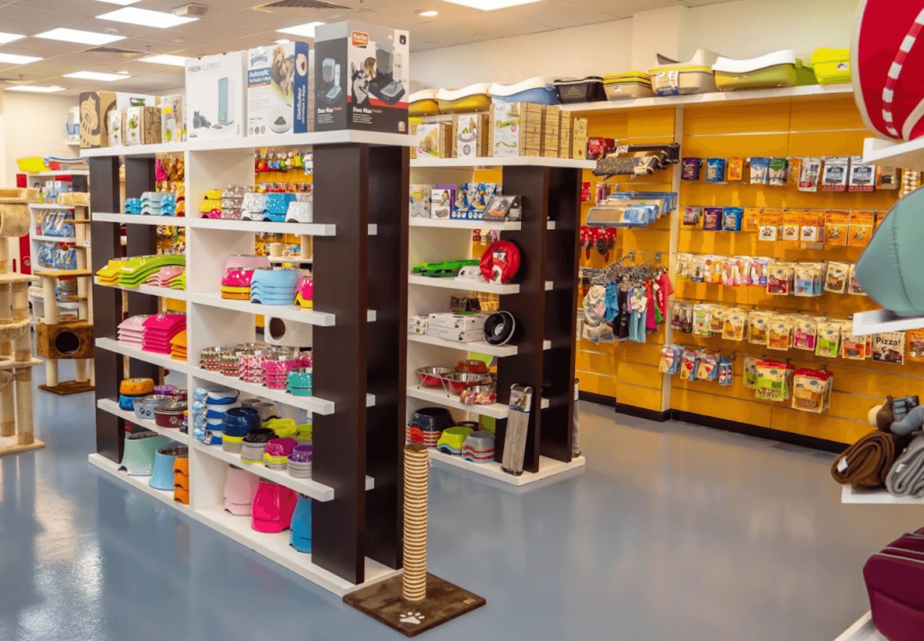 Shelves full of pet supplies, commercial food, and pet accessories at Pet Mart.