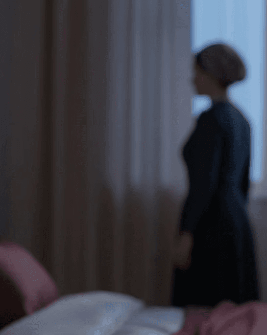 A circle of people sitting cross-legged, meditating with hands in a prayer position. Soft, warm lighting.