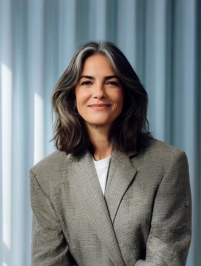 Portrait of a woman with short hair smiling in soft, muted lighting