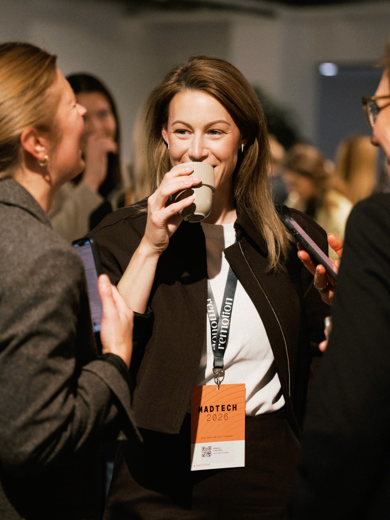 Besökare med MadTech 2026-bricka dricker kaffe och skrattar i minglet