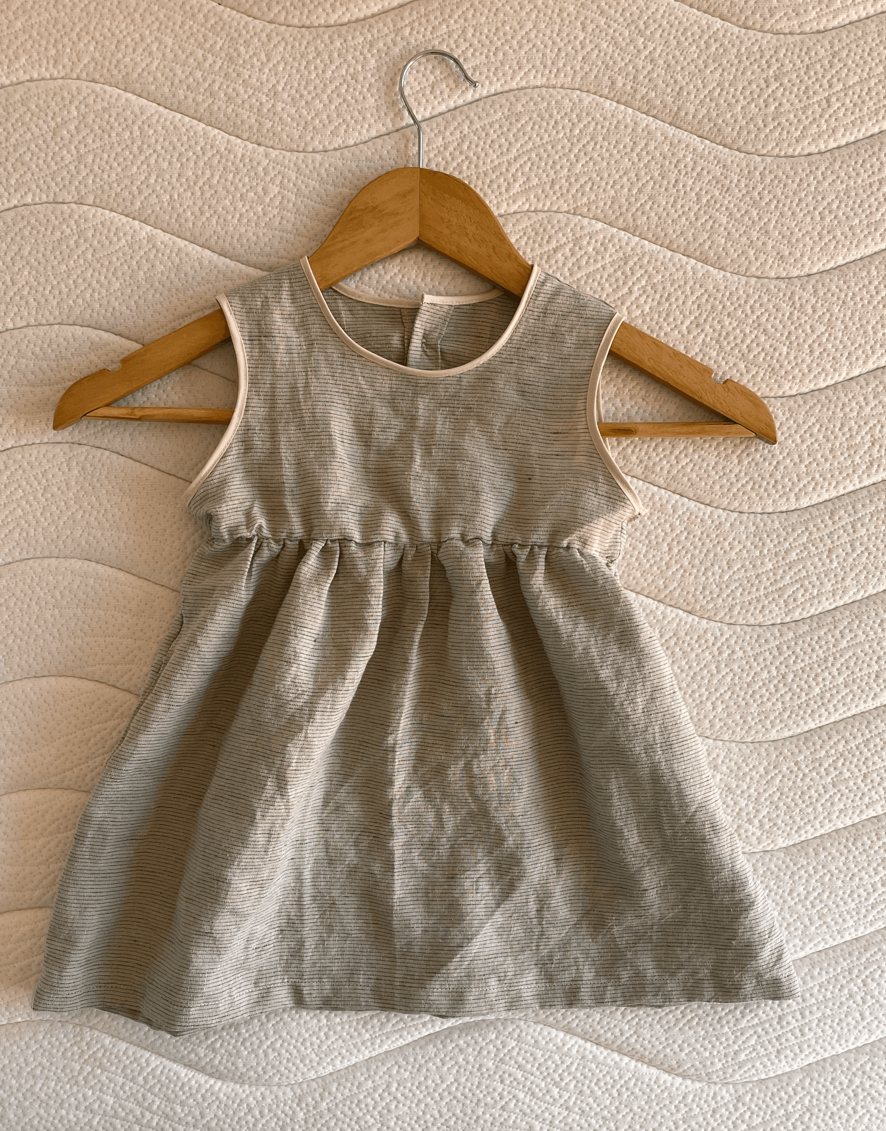 Front of a baby's sleeveless green dress 