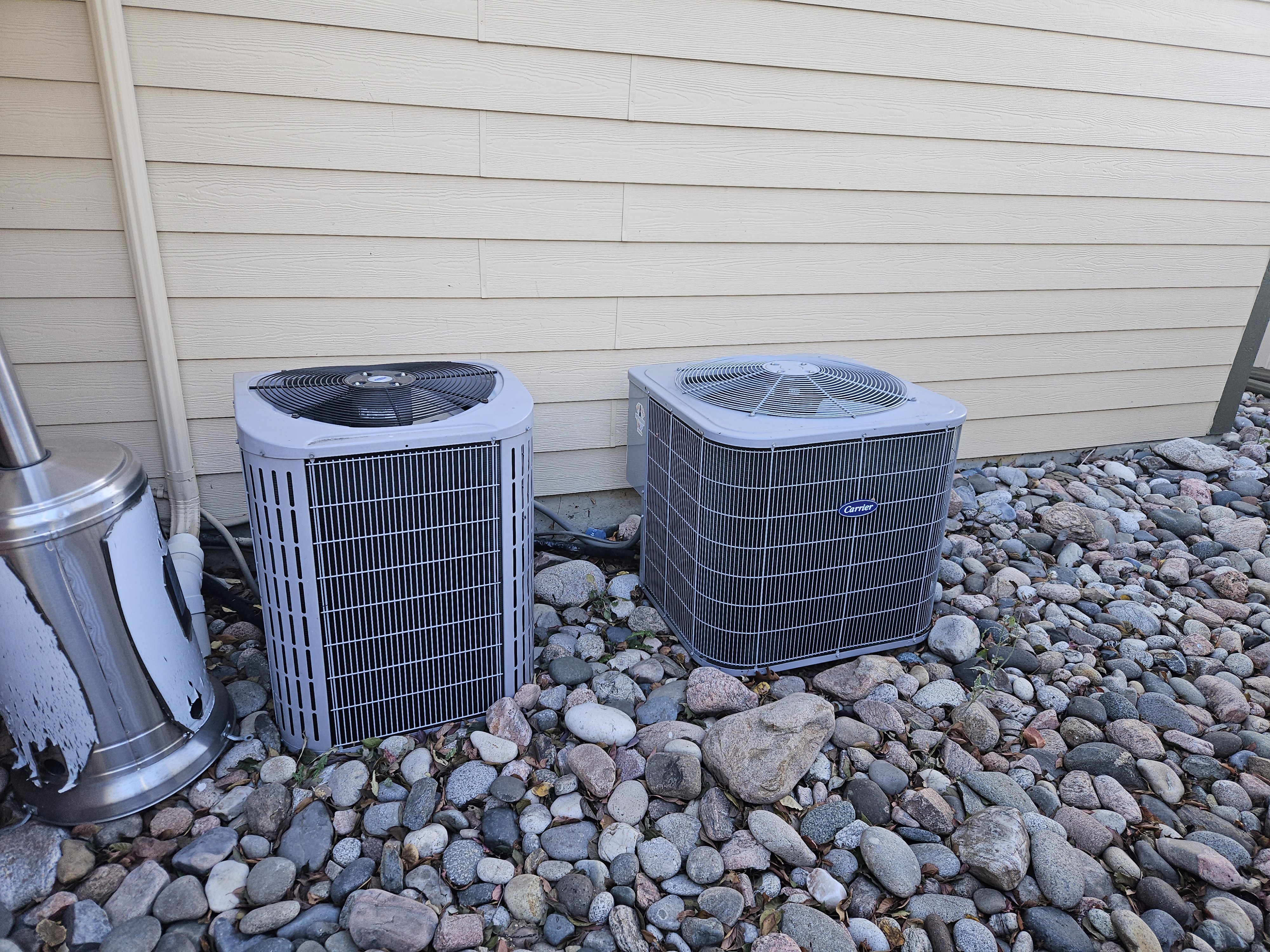 The image displays two Carrier outdoor air conditioning units. 