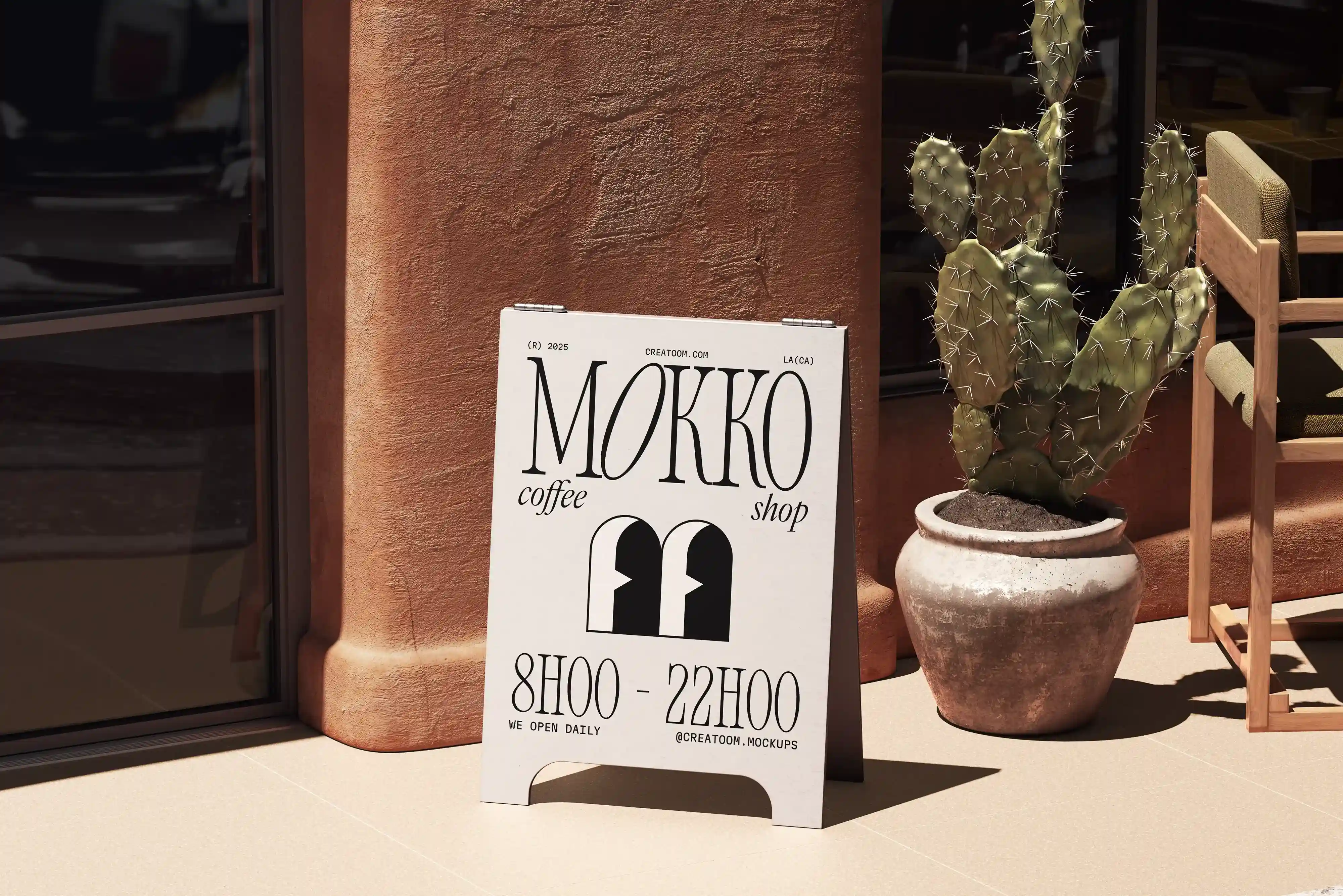 Branded sidewalk sign for Mokko coffee shop beside cactus and terracotta facade