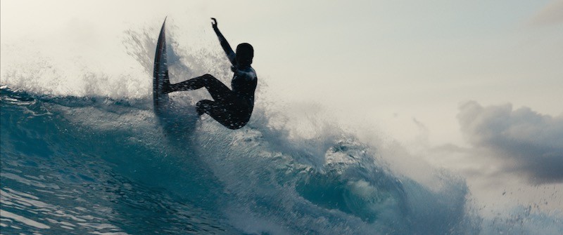 Surfer girl snapping her board against the lip of the wave