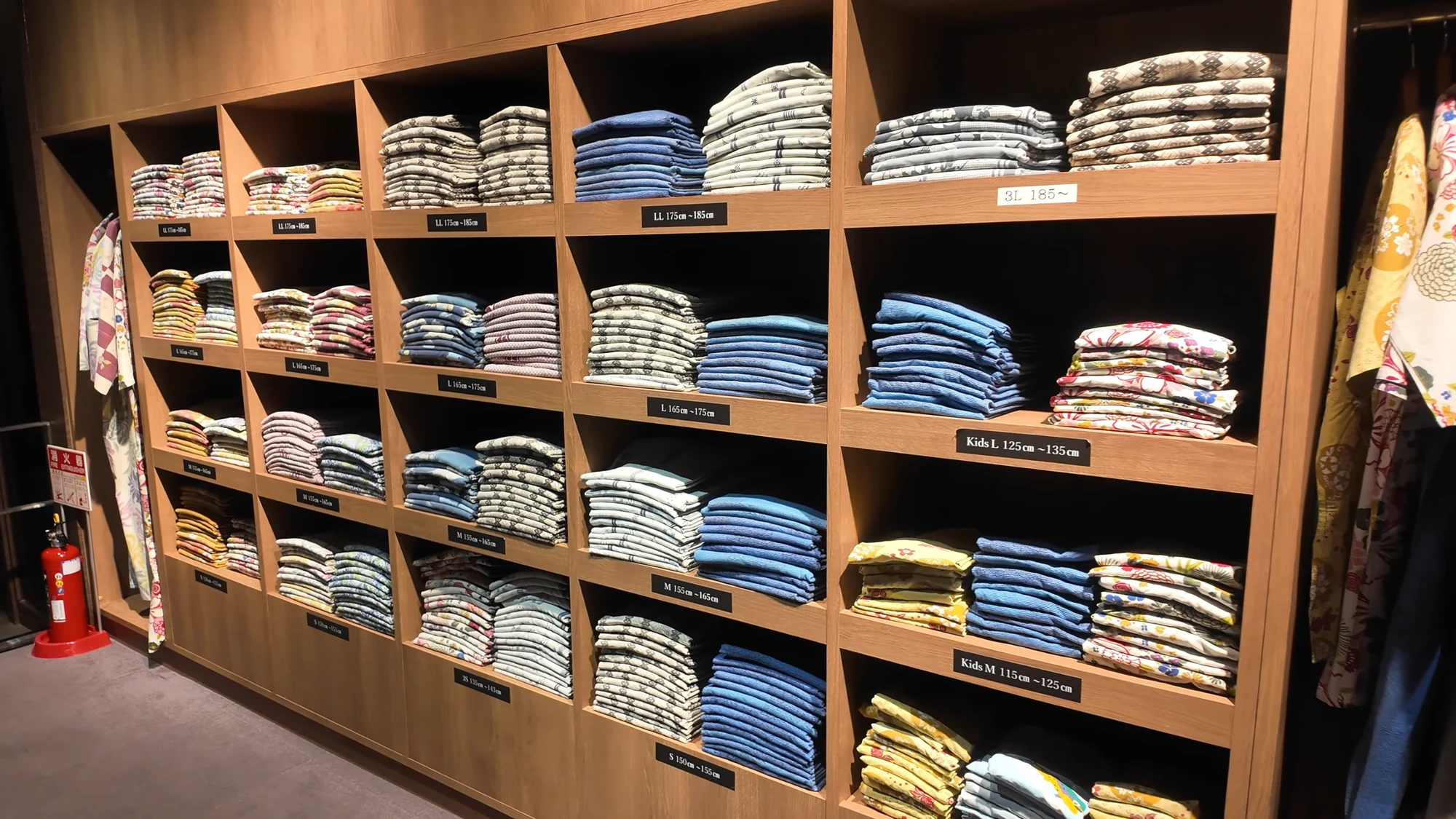 Shelves of folded rental yukata sorted by size in a Kinosaki inn.
