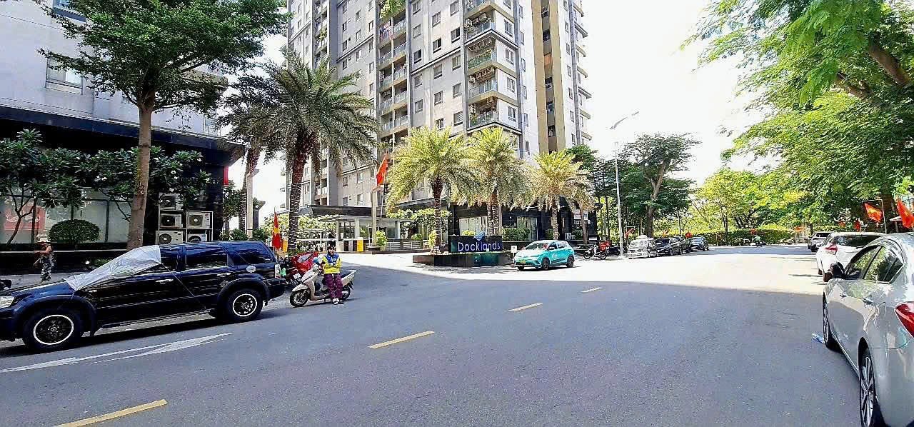 Contemporary bedroom with dark accent wall, pendant lights, and neutral bedding.