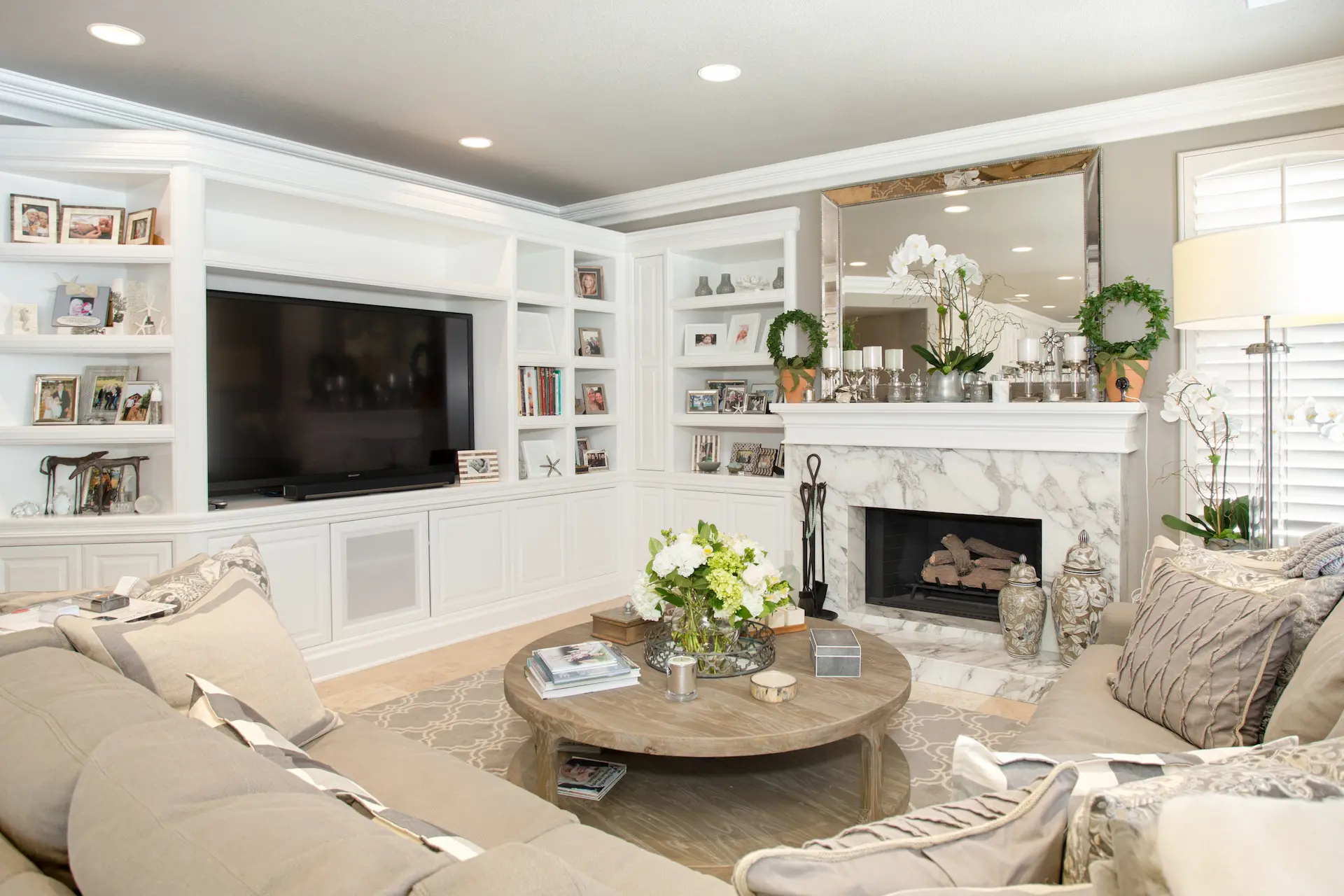 Cozy living room with fireplace, built-in shelves, and plush sofas in Newport Beach Remodel.