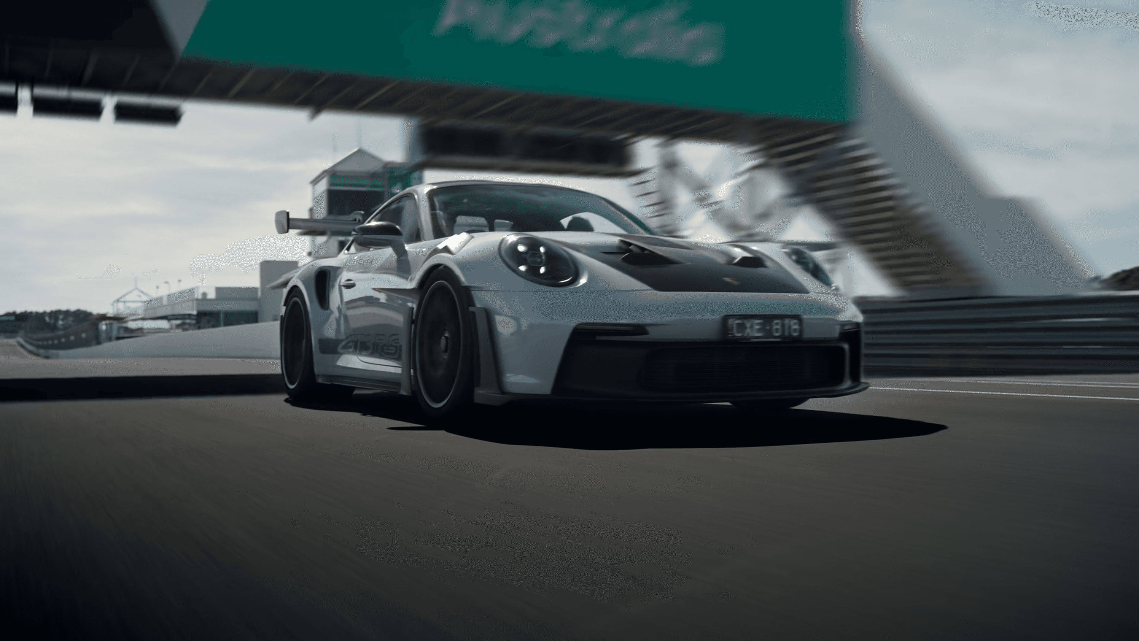 A view of two tall buildings rising above a green park, with trees in the foreground and a clear sky above