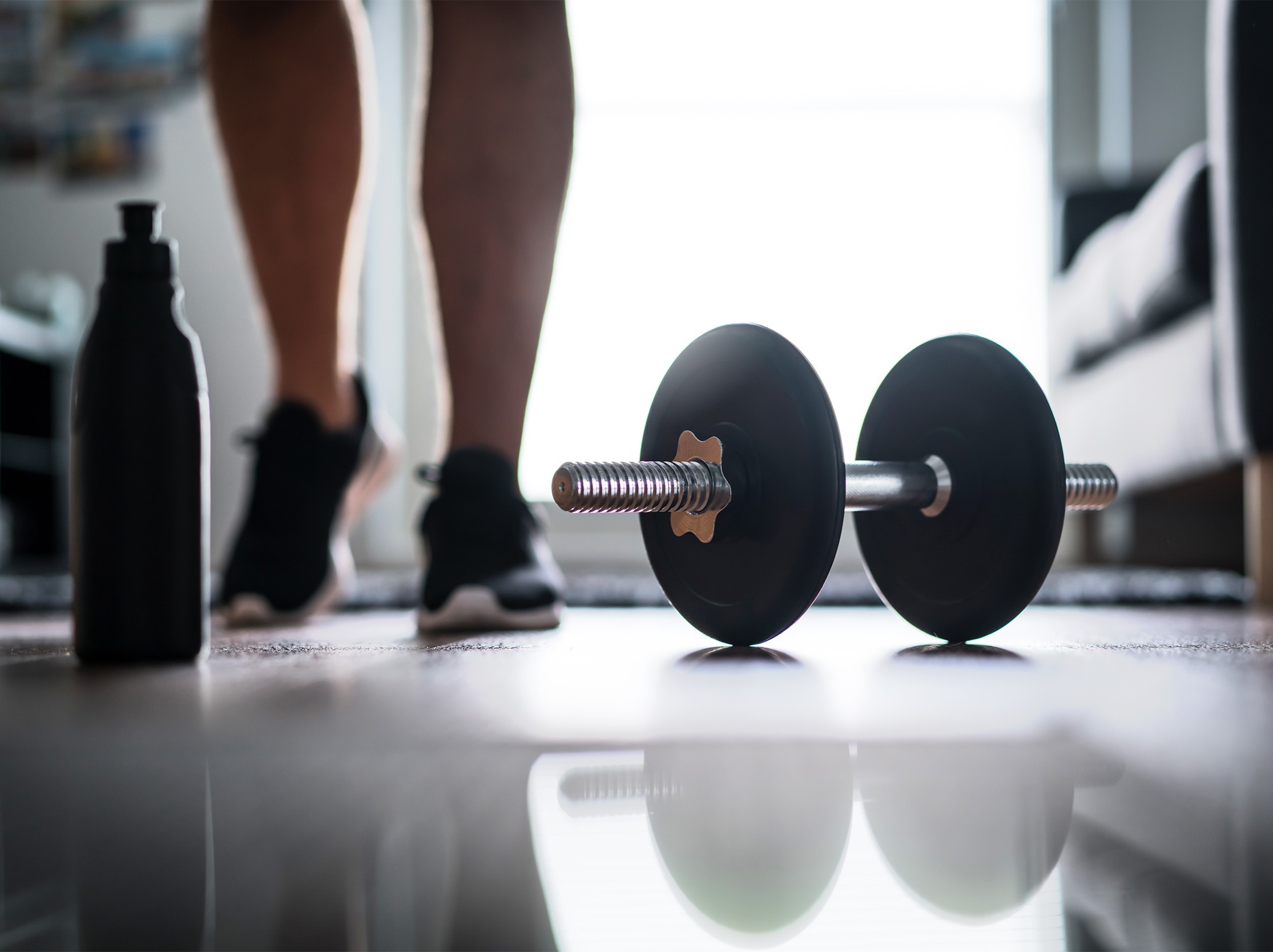 closeup of a person walking towards their workout equipment to do at-home exercises to lose weight