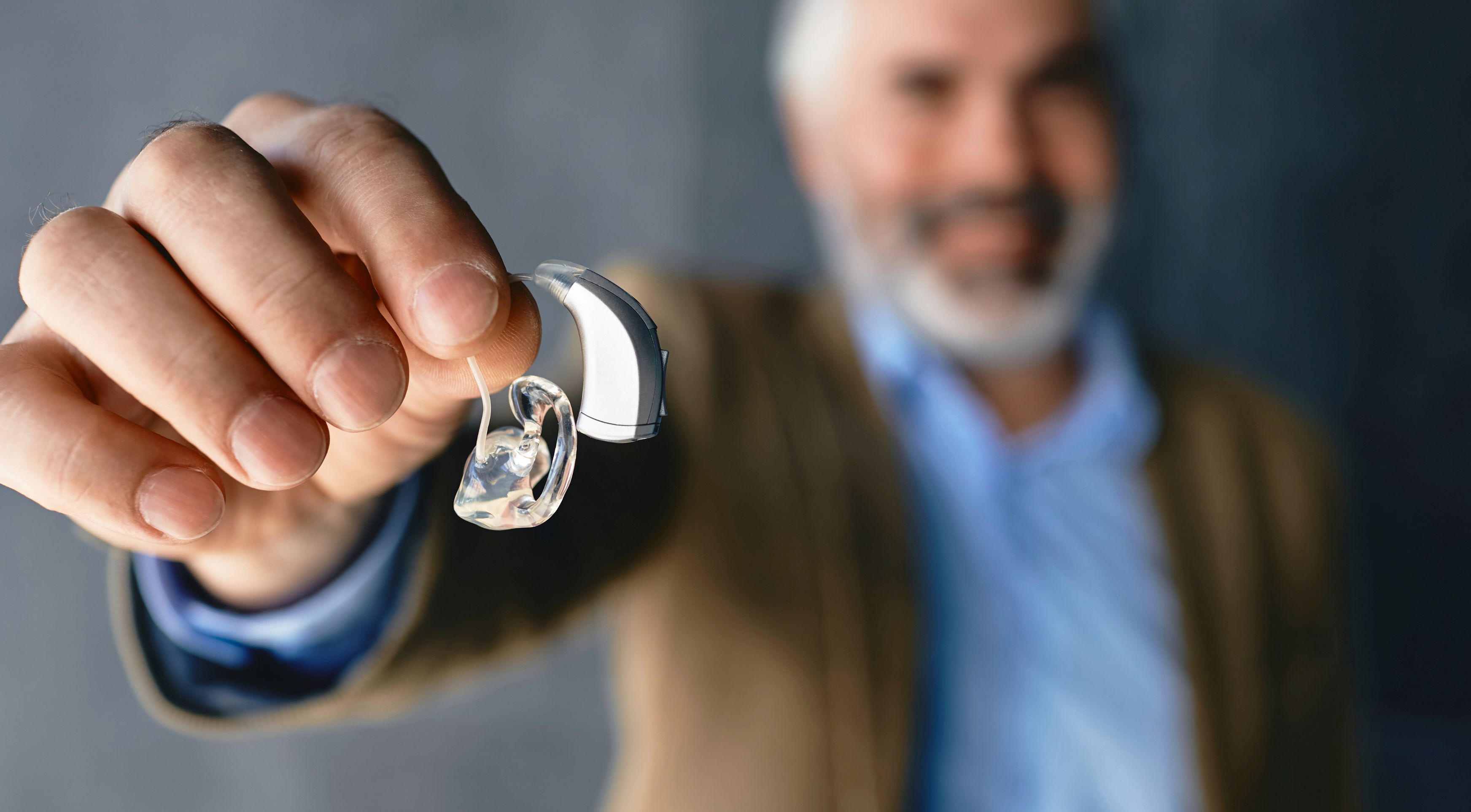 Fran, jefe de proyectos, colocándose un audífono con gesto serio y profesional