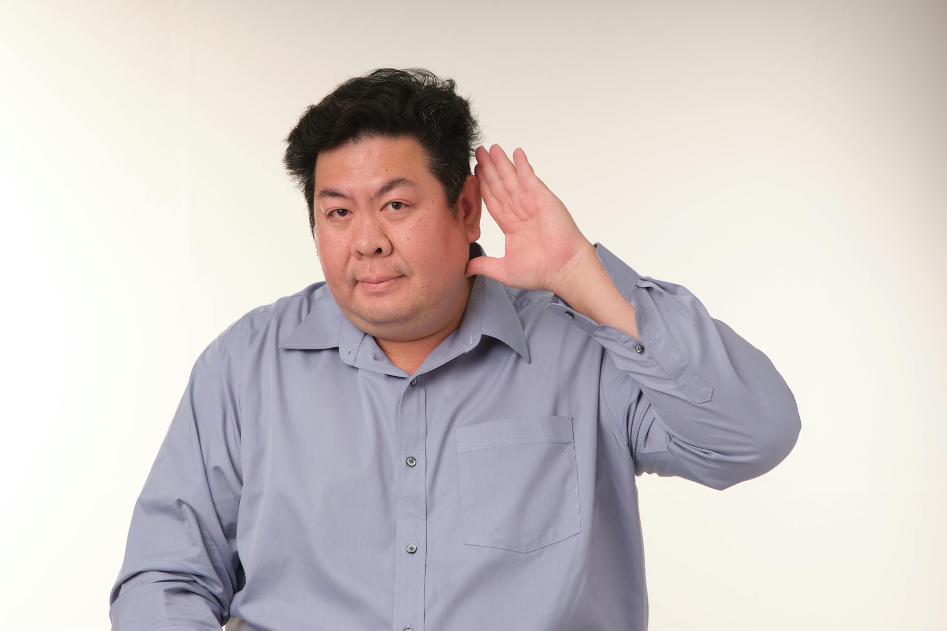 A young student tilting their head and focusing closely on the sounds of a nature documentary in a classroom.