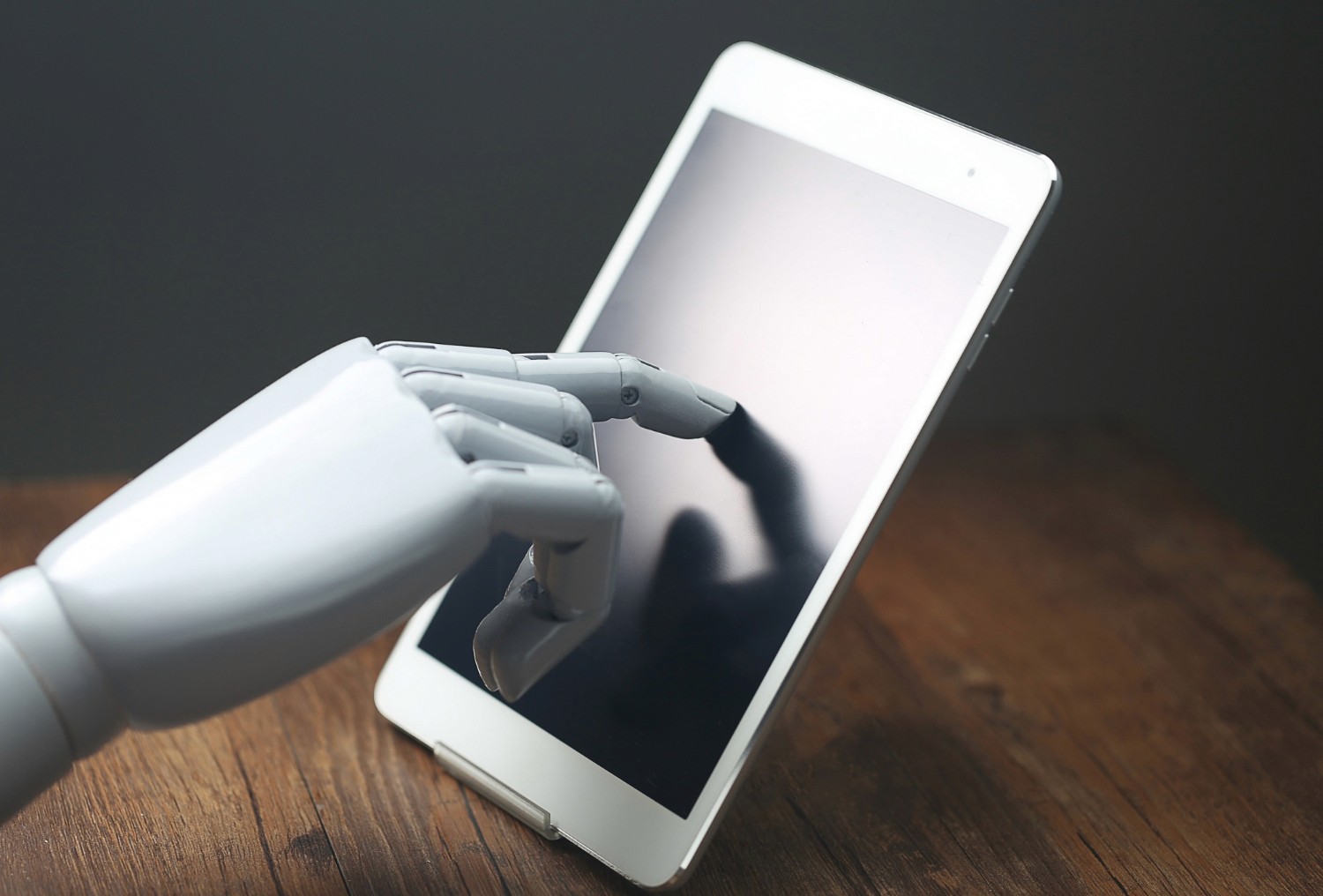 Robotic hand touching a tablet screen
