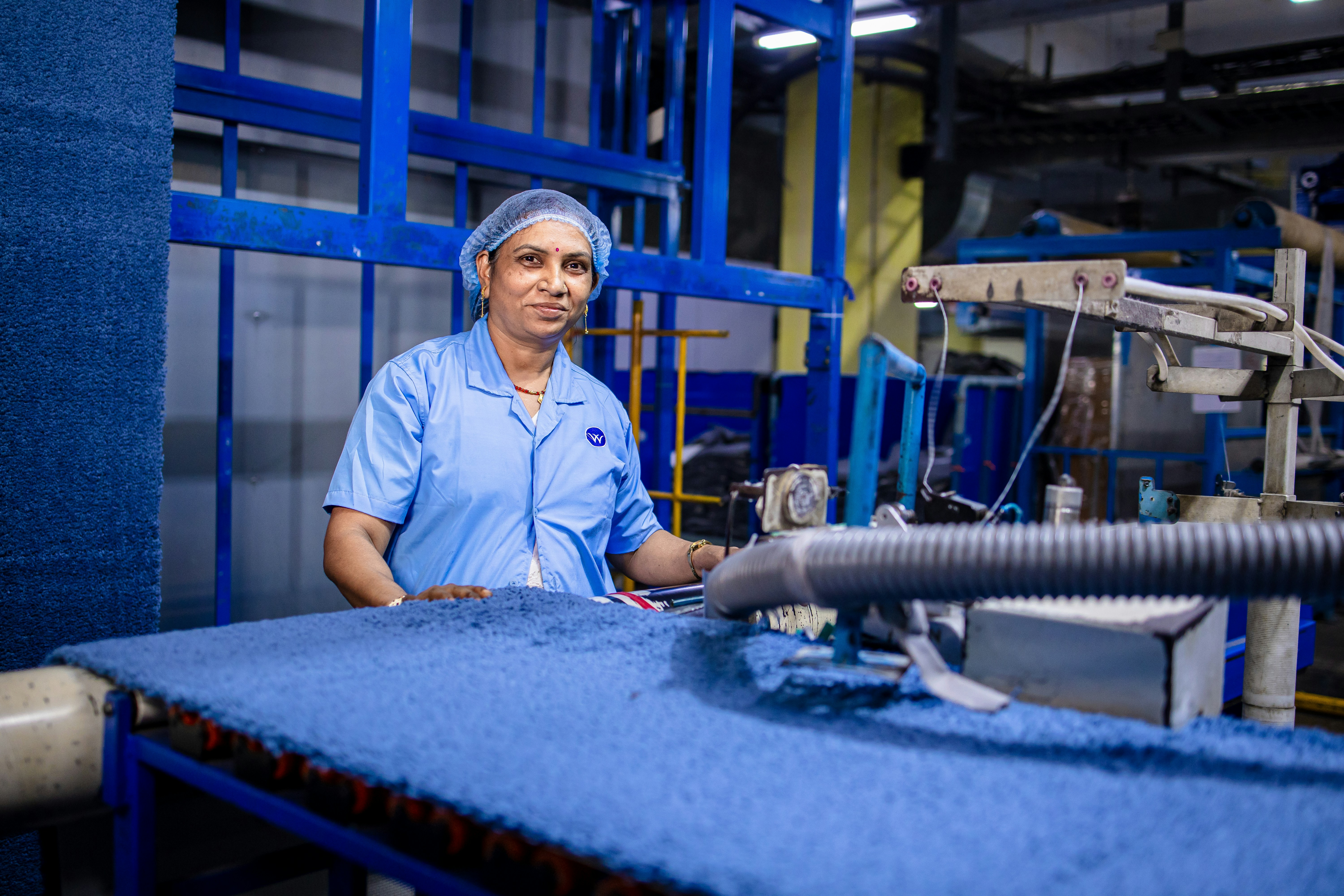 A worker uses a vacuum in a factory.